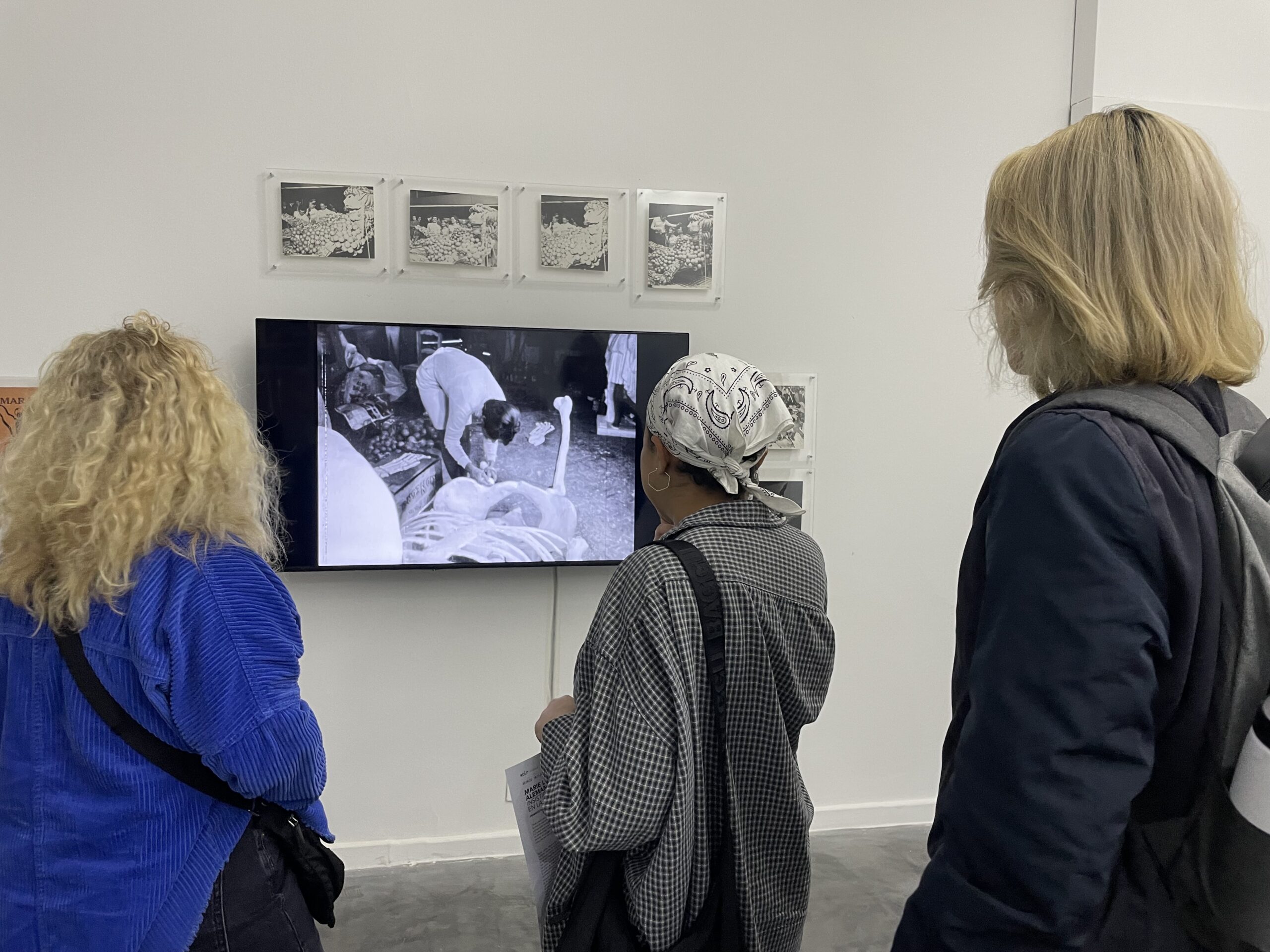 Several students observe an art show curated by an NYU professor.