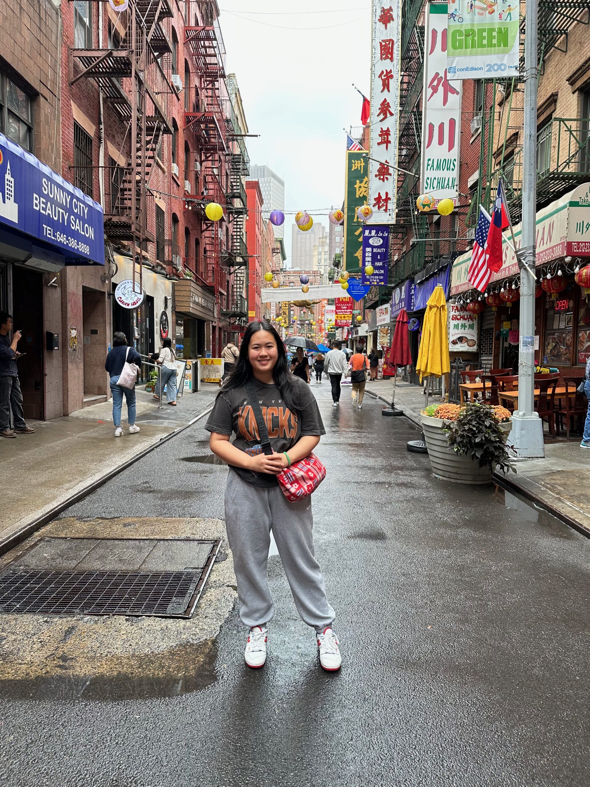 The author stands in the middle of a street in New York City’s Chinatown.