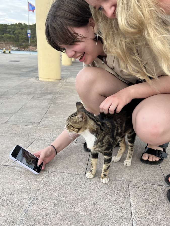 The author and a friend stop to take a picture with a stray cat in Athens, Greece.