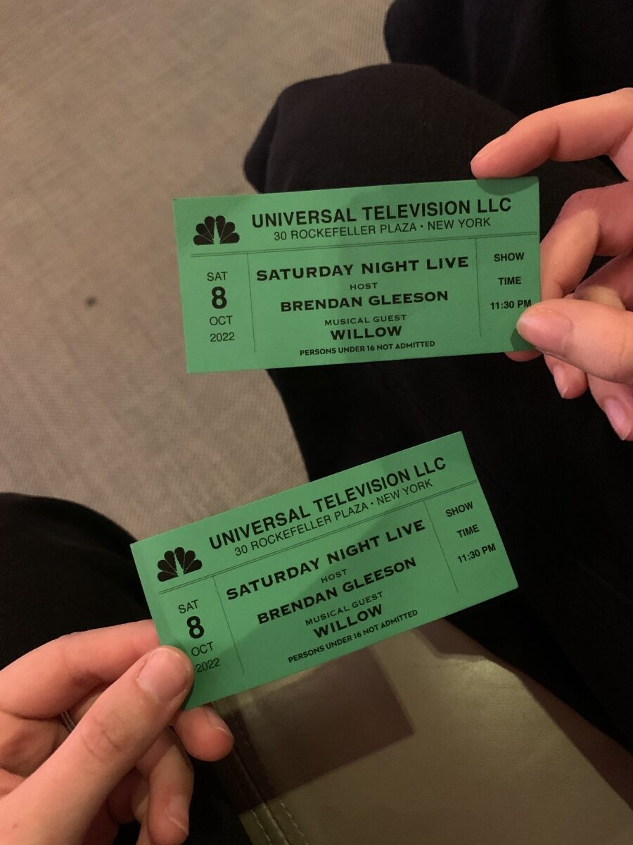 Two green SNL tickets in people's hands (media)