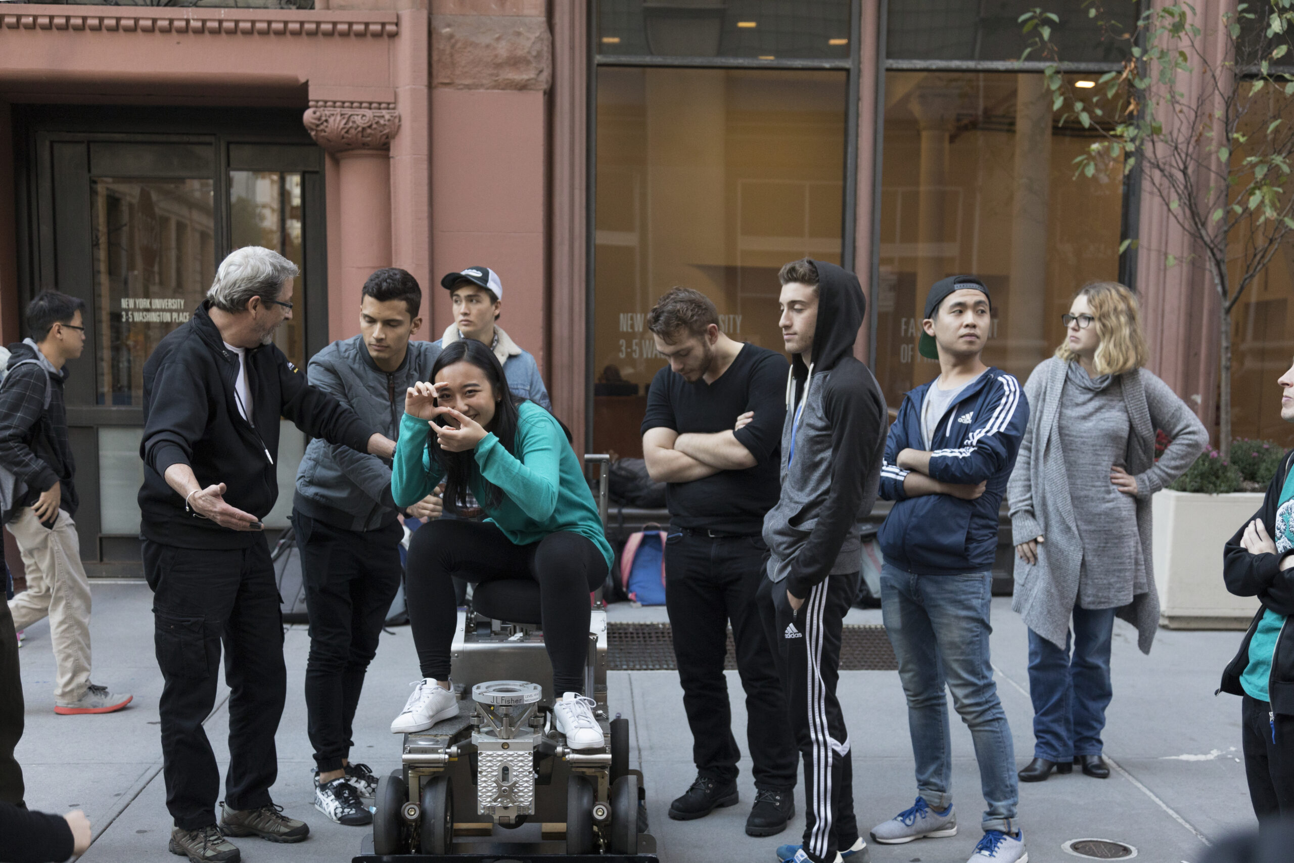 Students, with their professor’s guidance, trying out film equipment during a class outing.