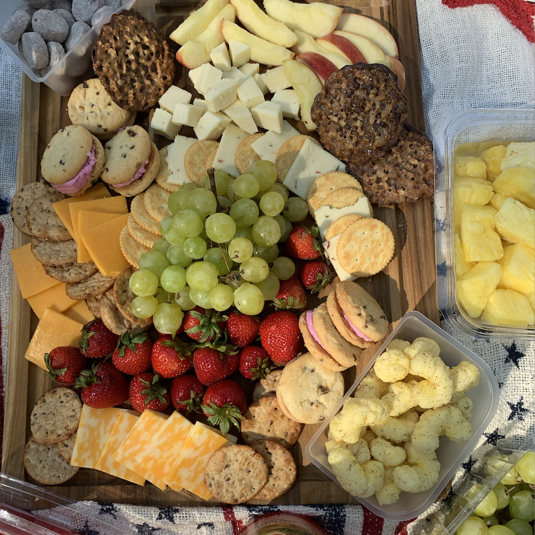 A spread of grapes, cheese, and crackers for a picnic in Central Park.