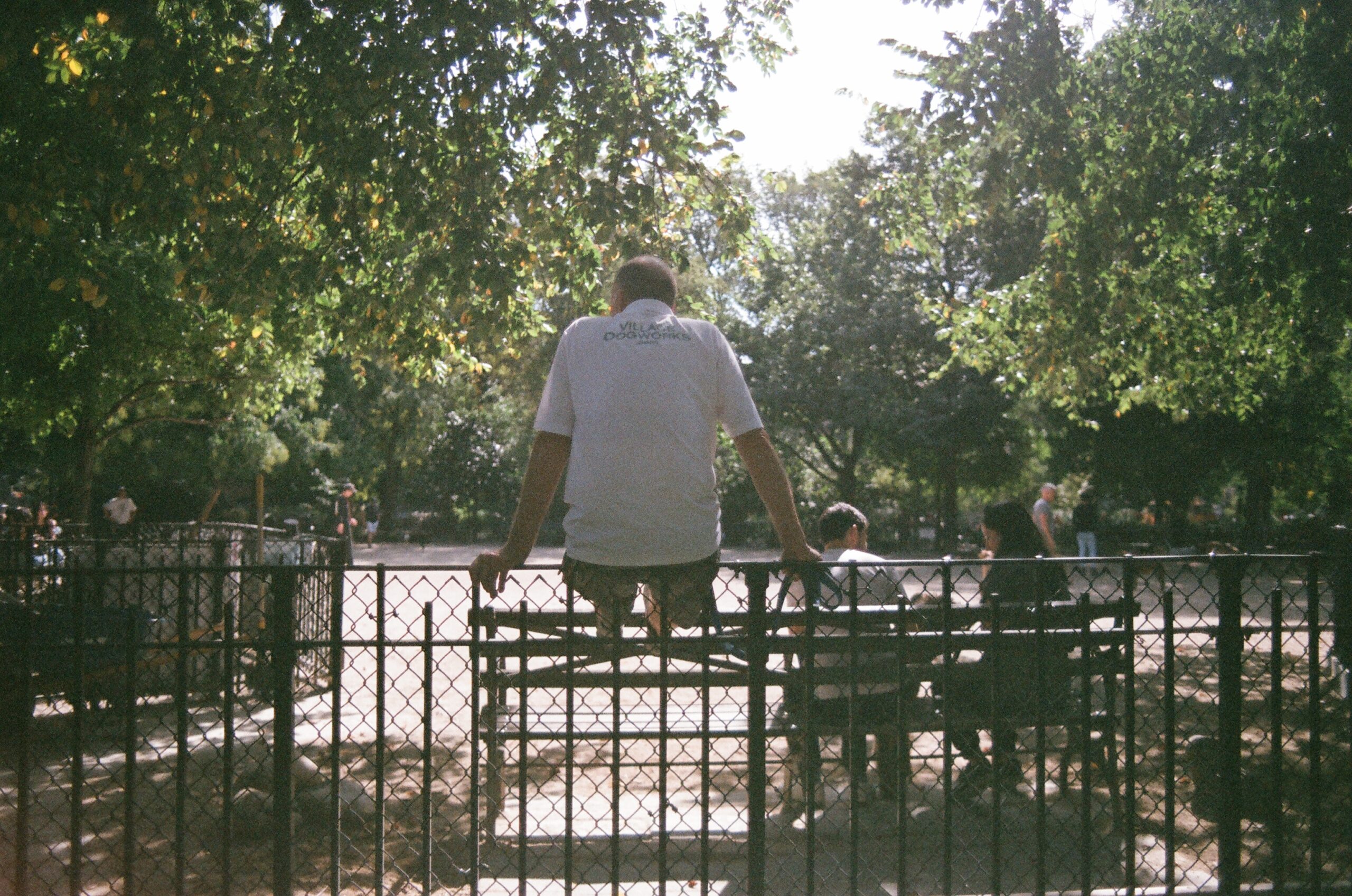 A man sitting on a gate at Tompkins Square Park