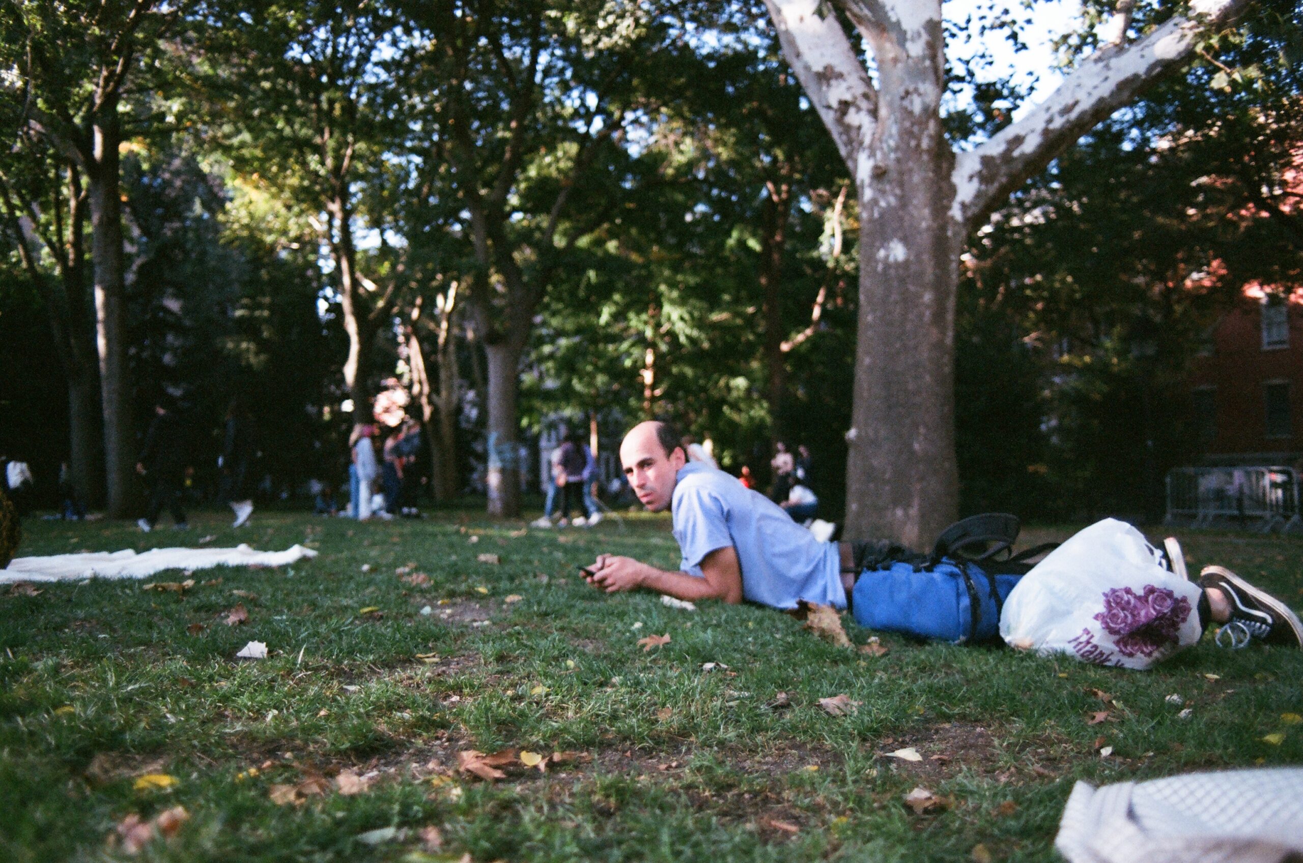 Man laying down in grass at park.