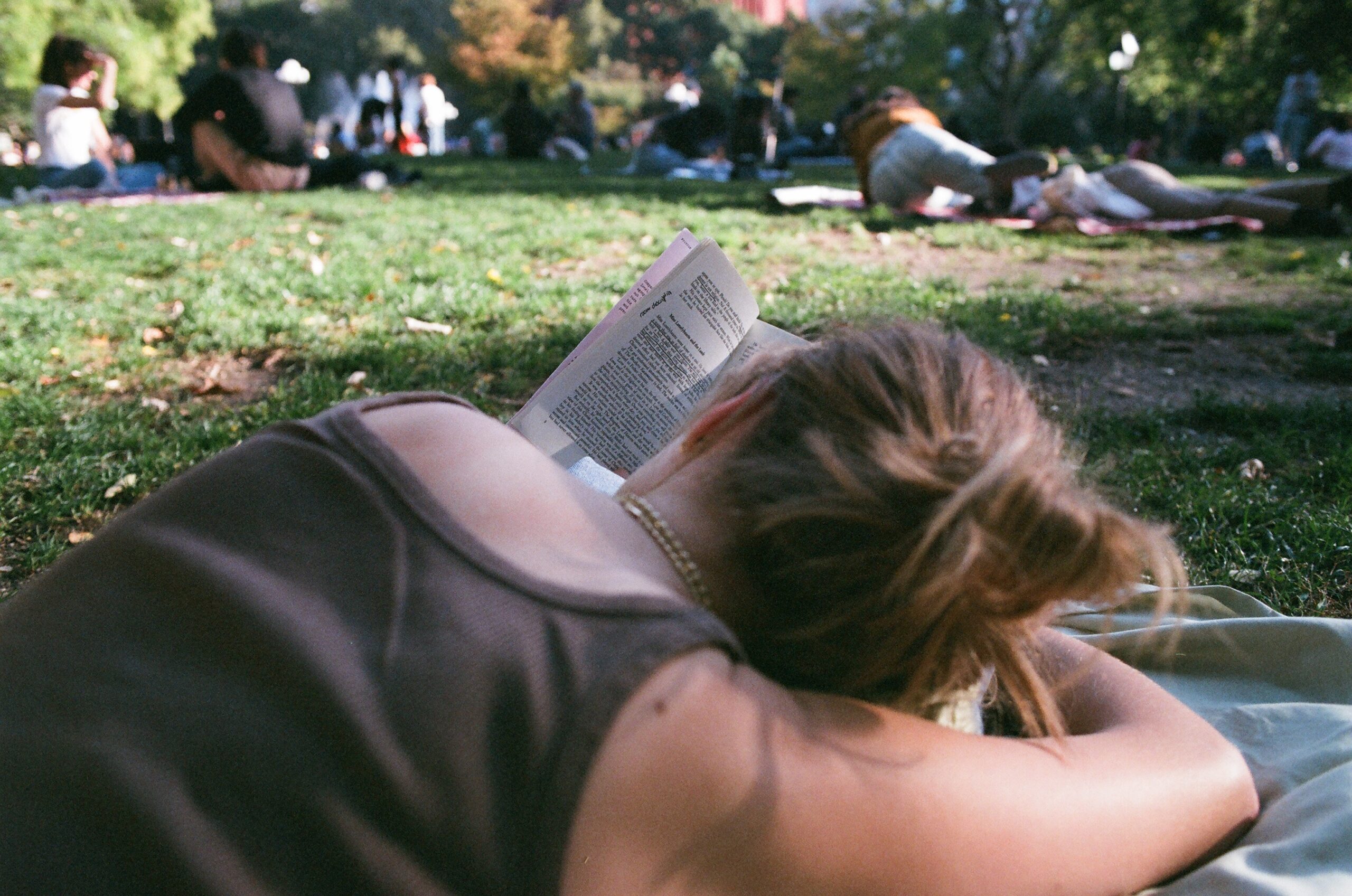 Girl reading book in Washington Square Park.