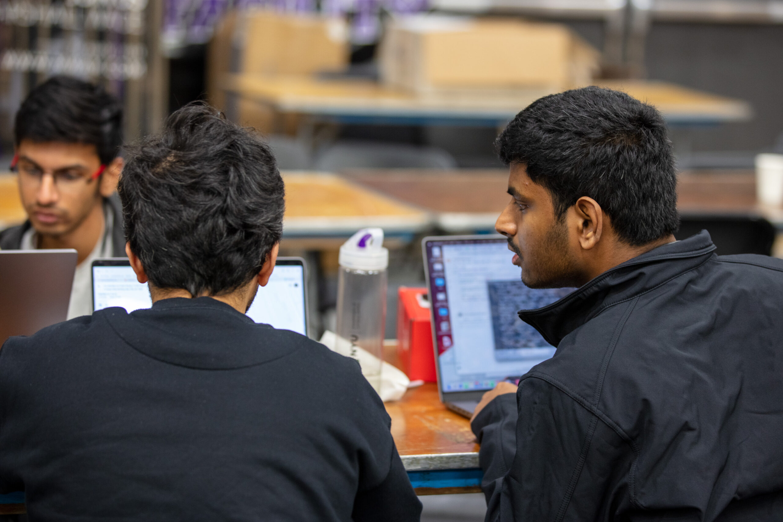 Two students working together during the NYU Hackathon event.