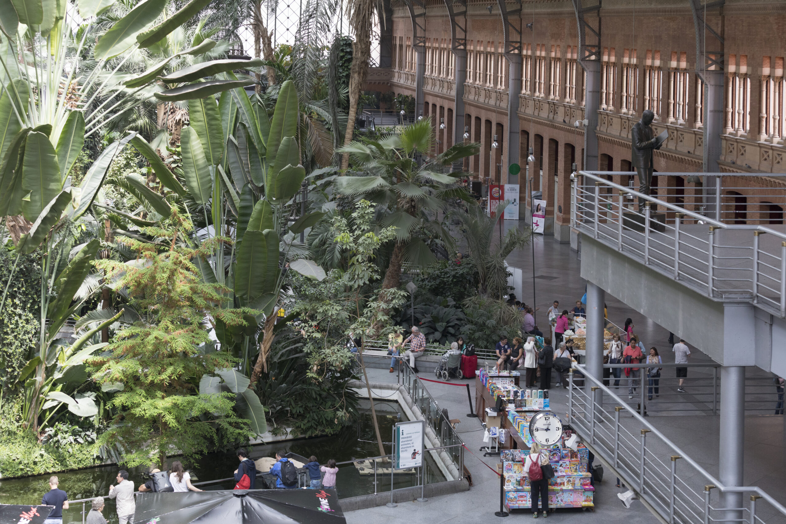 The interior of Atocha railway station in Madrid, showcasing its historic architecture and bustling surroundings.