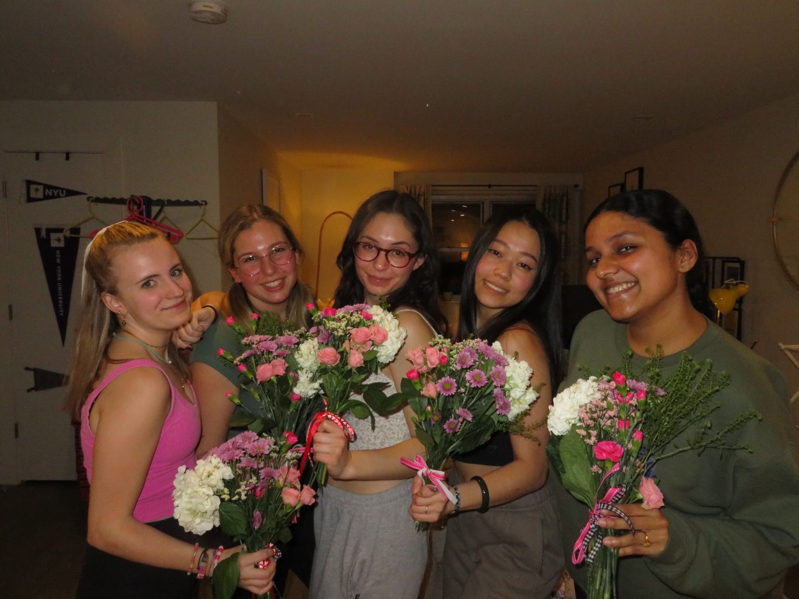 five girls posing for a picture with bouquets