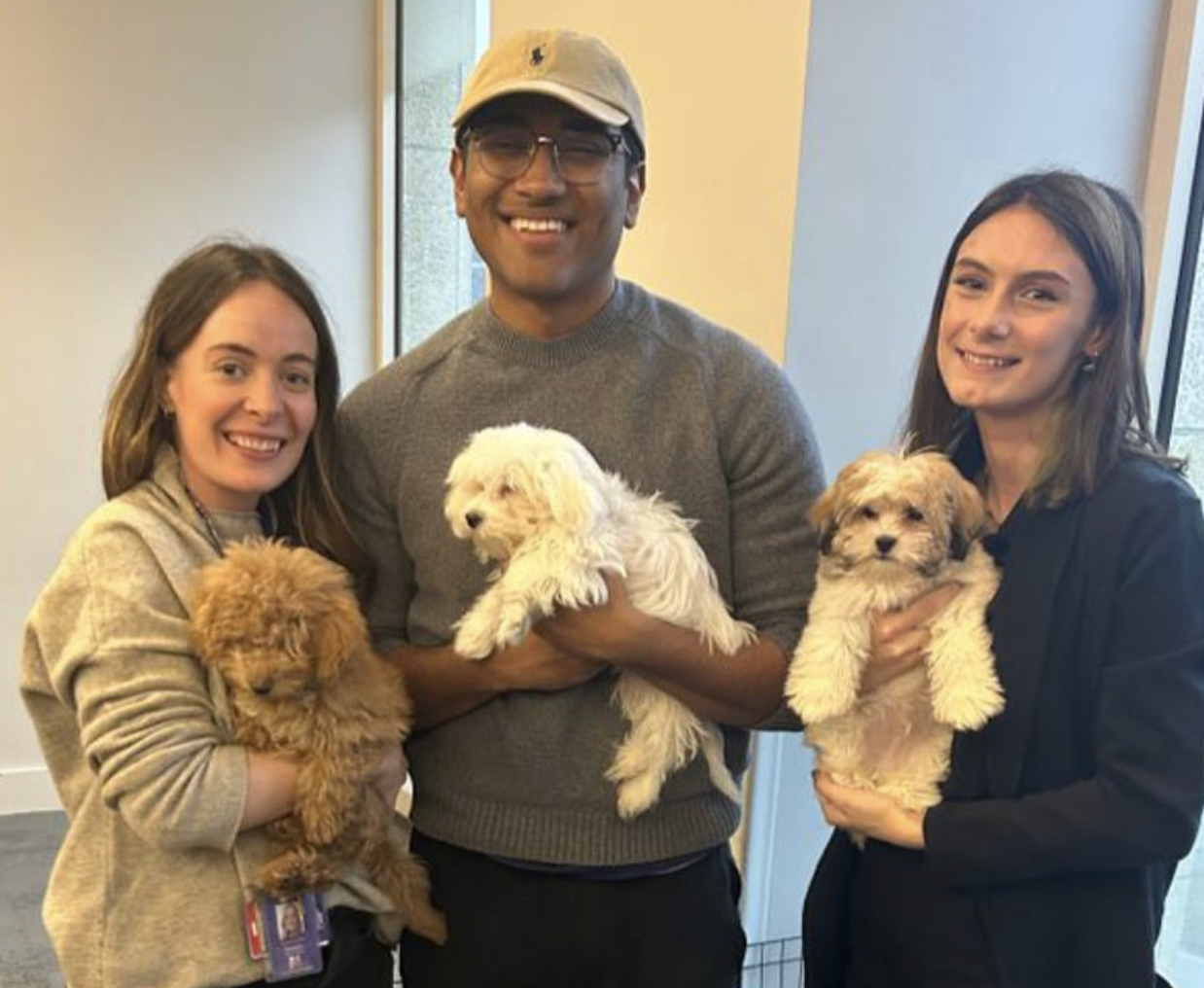 Students holding puppies and smiling.