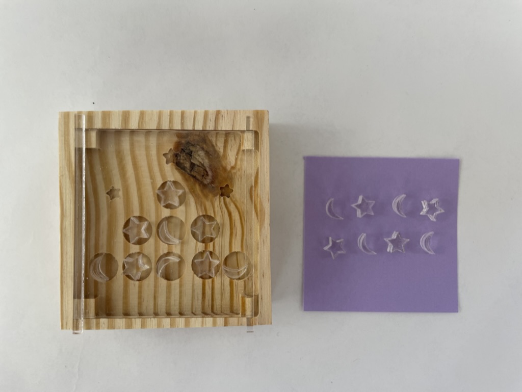A tic-tac-toe board the author designed. She used a computer numerical control machine to cut into the block of wood.