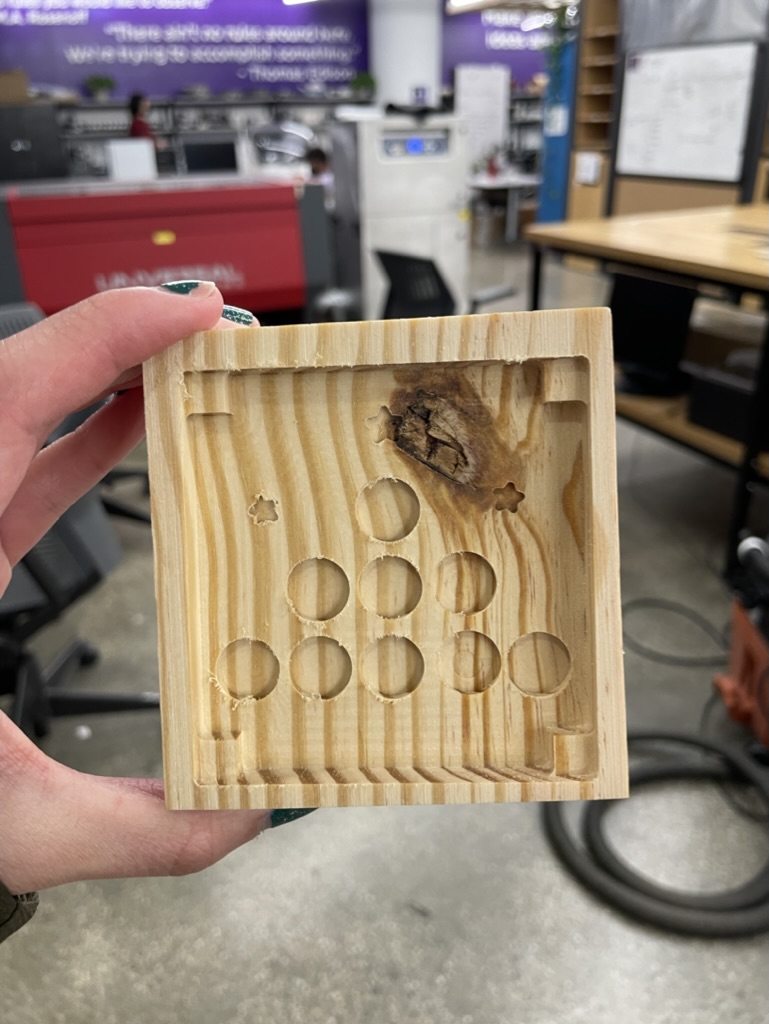 A tic-tac-toe board cut from a block of wood by the CNC Othermill printer at the NYU Makerspace.