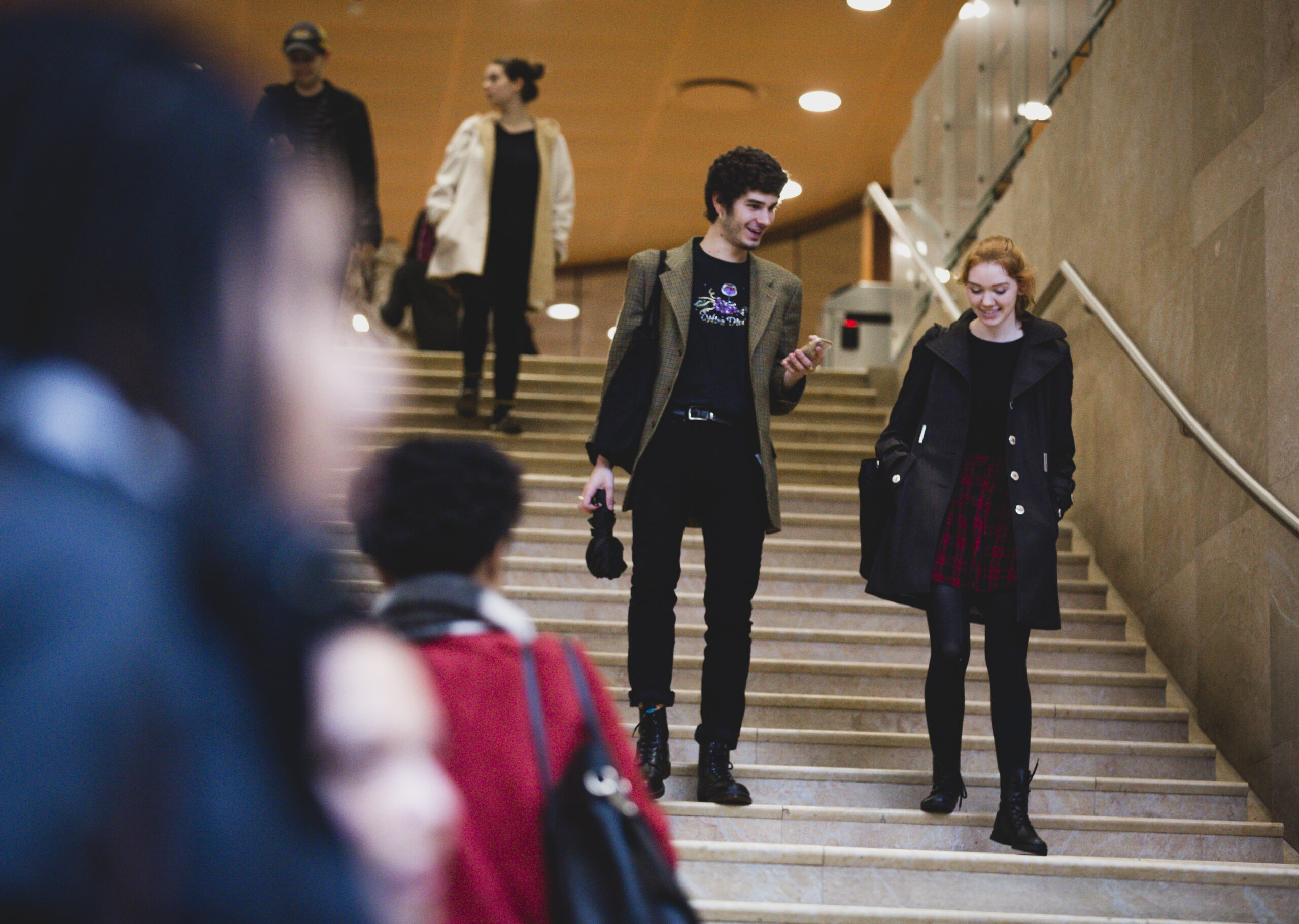 Two students walking down the Kimmel stairs while talking.