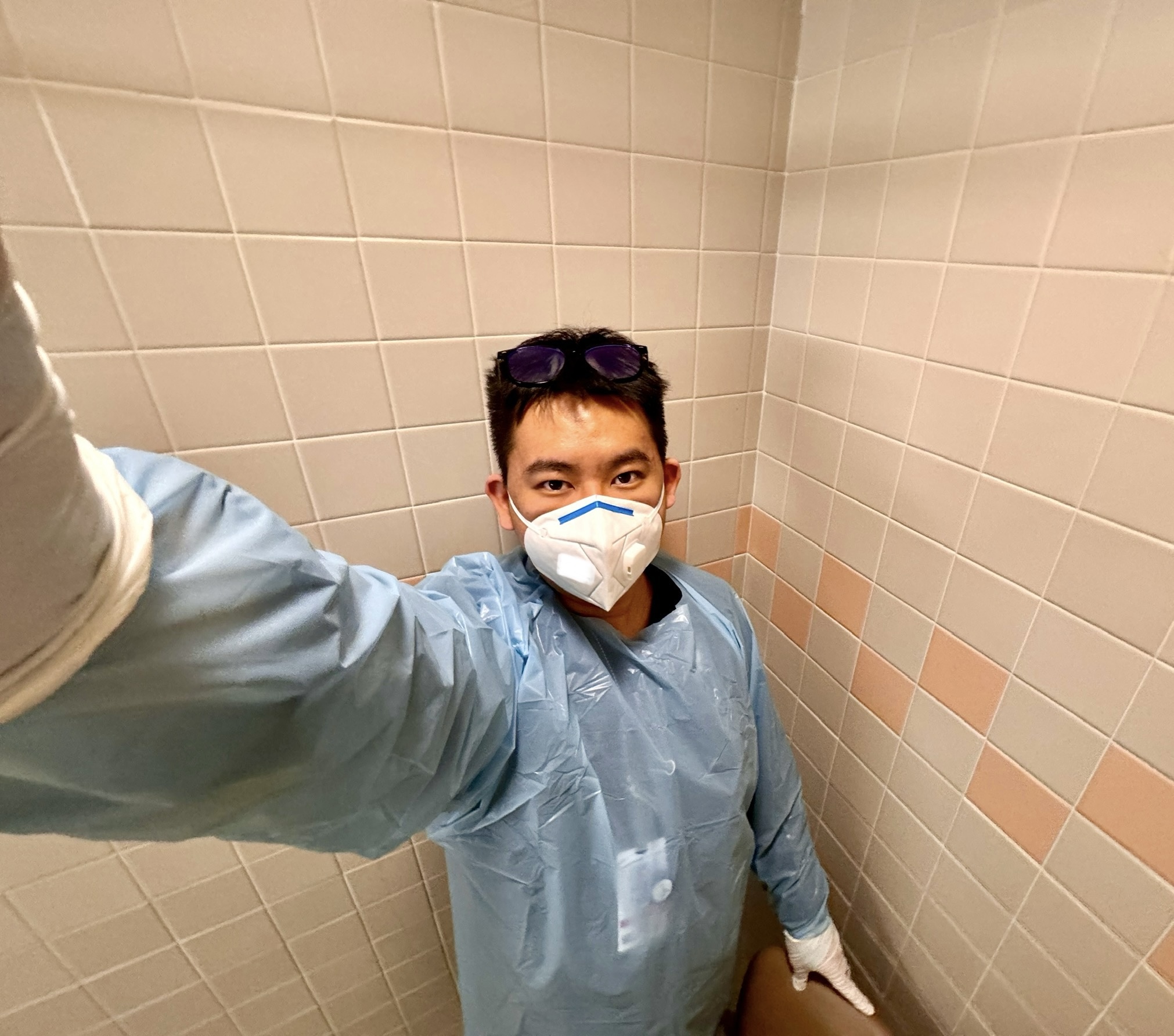 The author, a premed student, wears a protective gown and an N95 mask at a hospital.