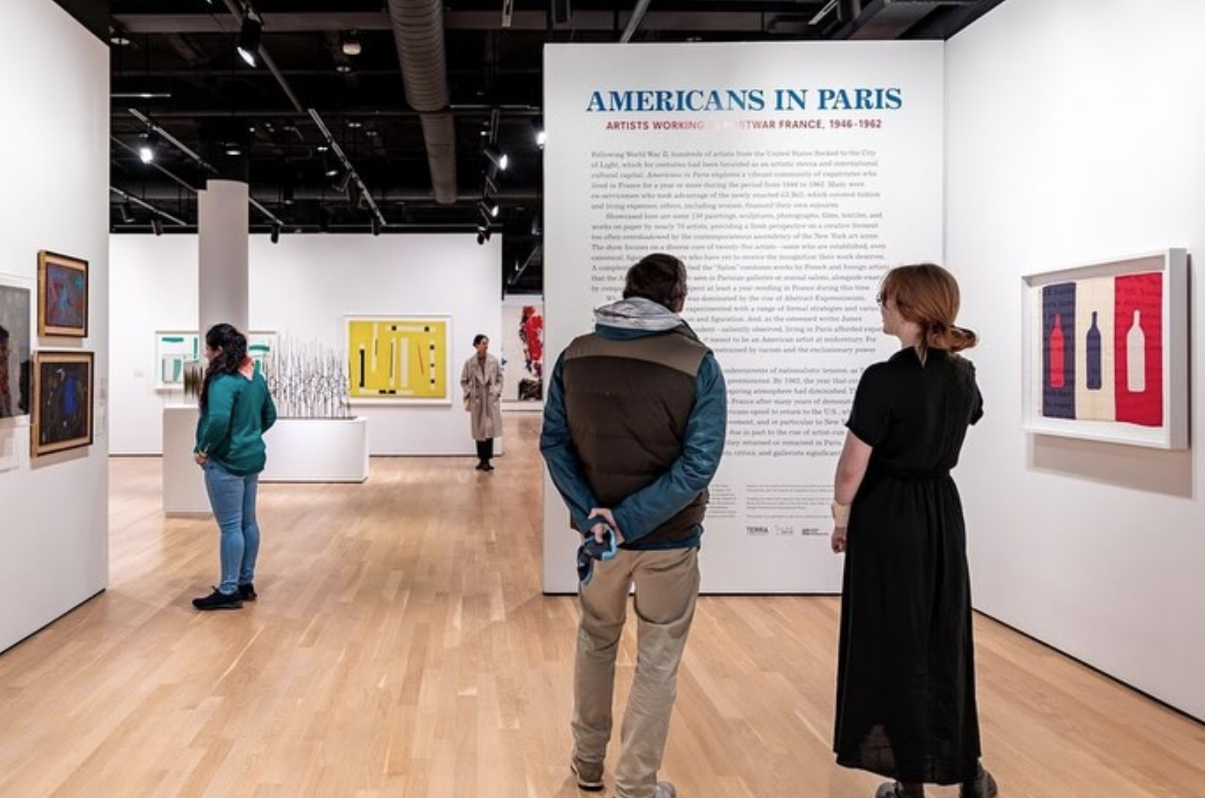 Visitors observing the “Americans in Paris” exhibit at the Grey Art Museum.