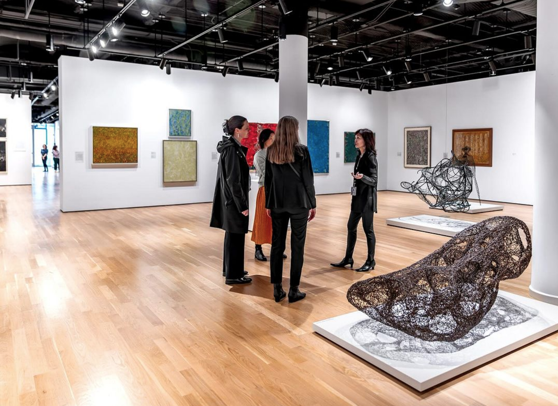 A guided tour group explores the exhibits at the Grey Art Museum.