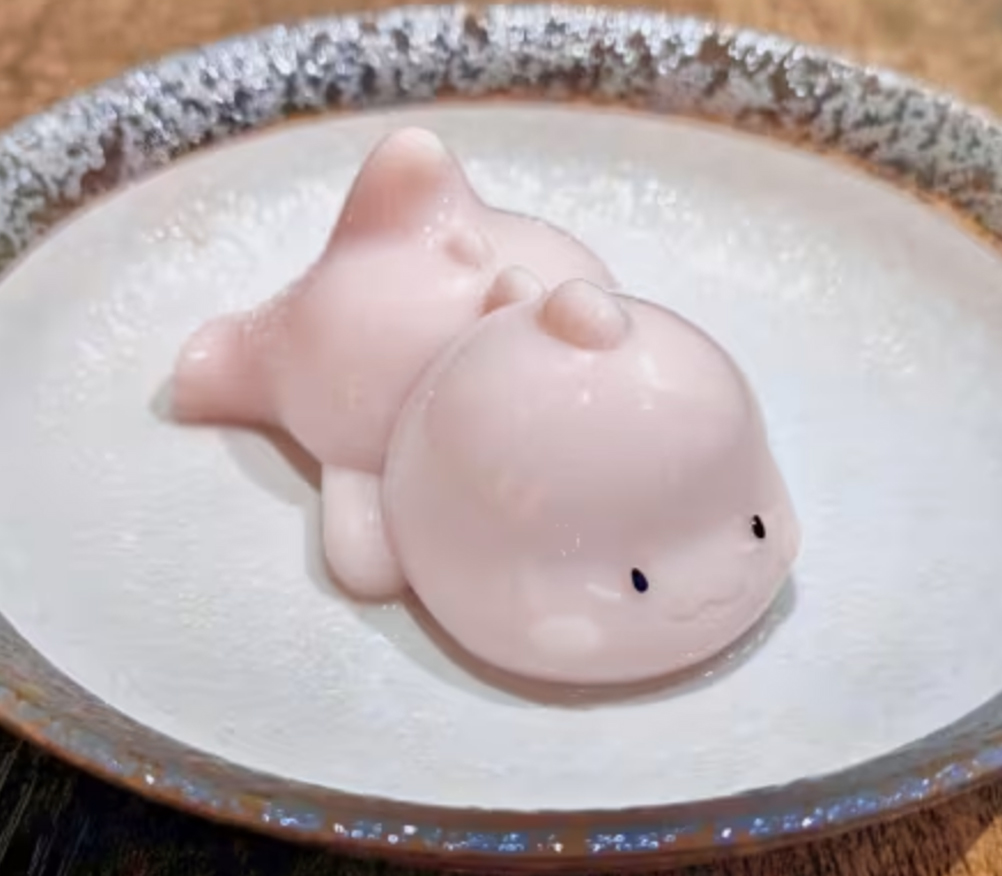 A small pale-pink jelly resembling a cartoon dragon.