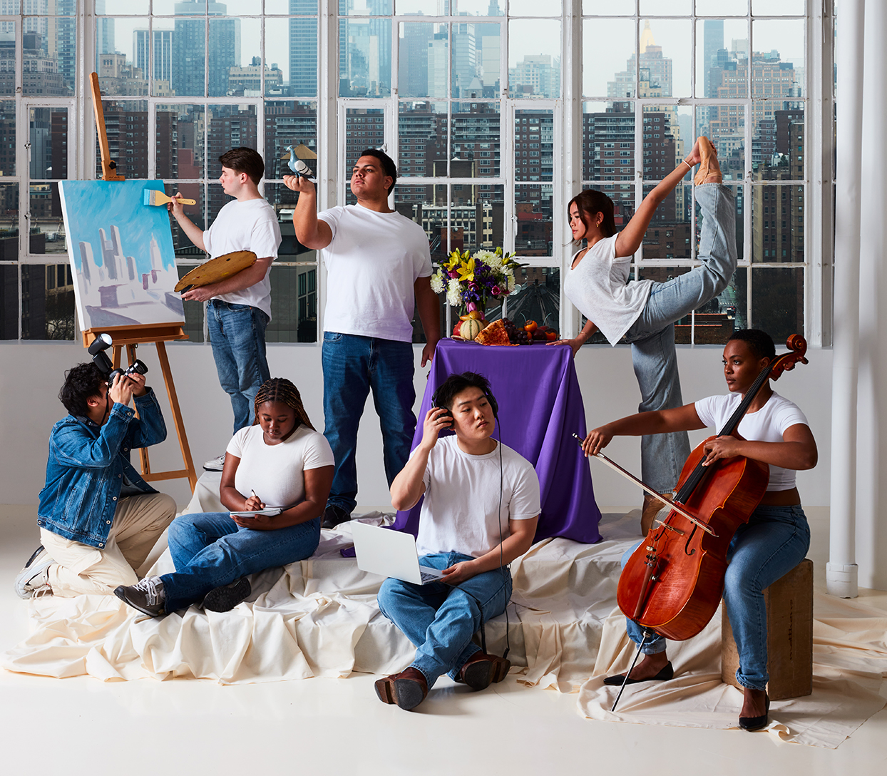 A diverse group of seven people, dressed casually in white T-shirts and jeans, engaging in the following artistic activities: painting, photography, writing, instrument playing, music production, acting, and dance in a bright studio with large windows overlooking a cityscape.