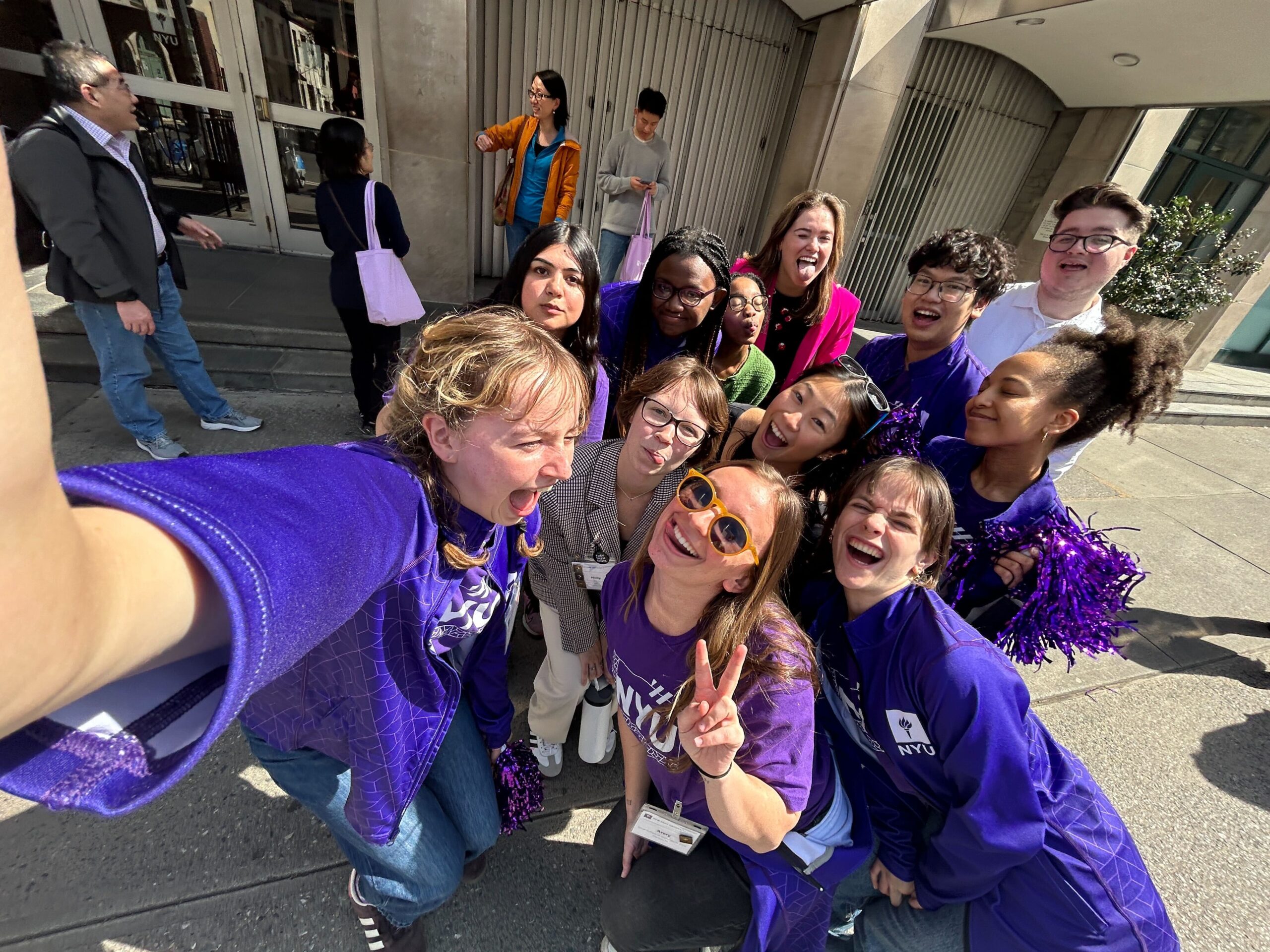 Students wearing NYU Violet posing for a selfie.