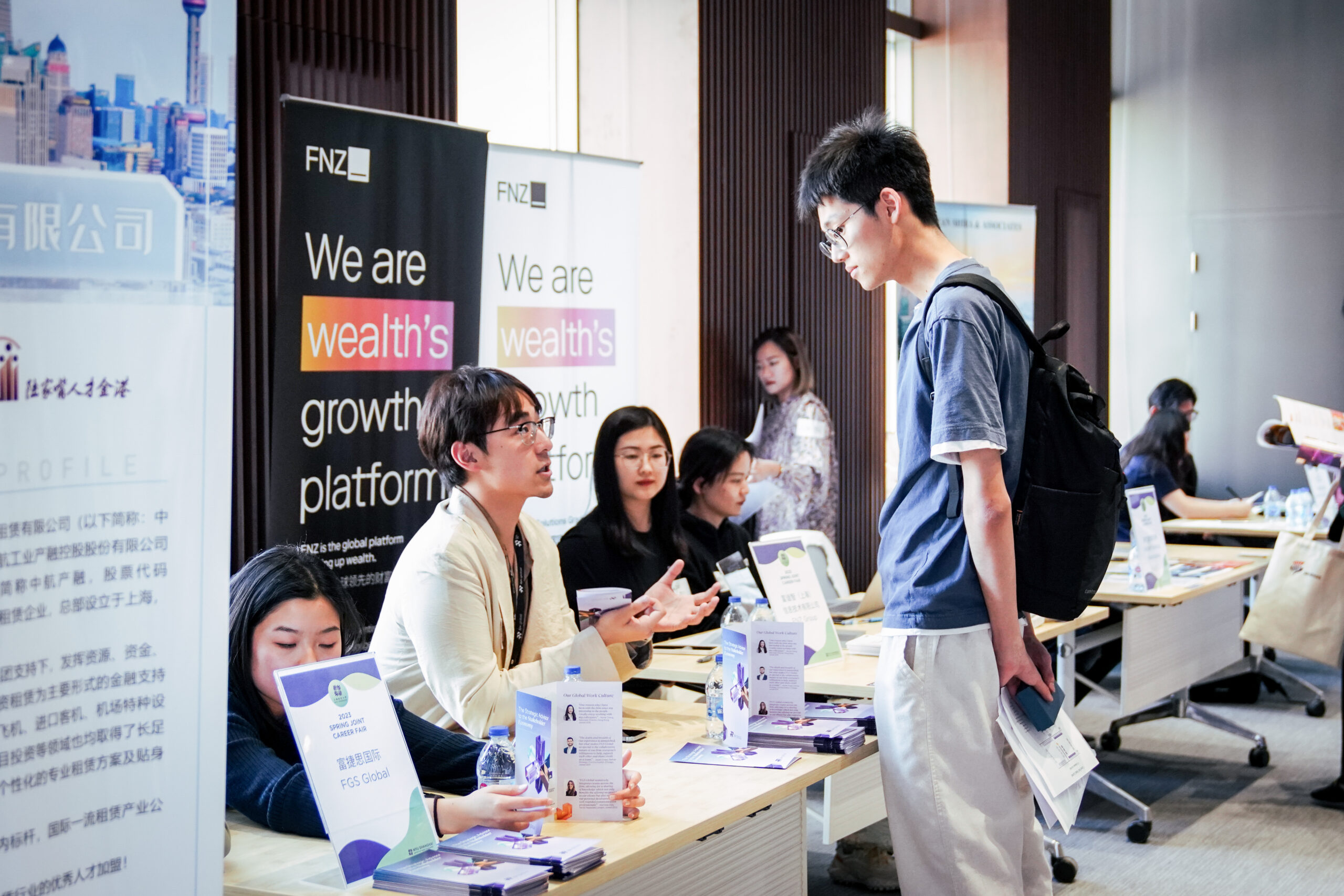 a student talks to people running a booth during a Colloquium event