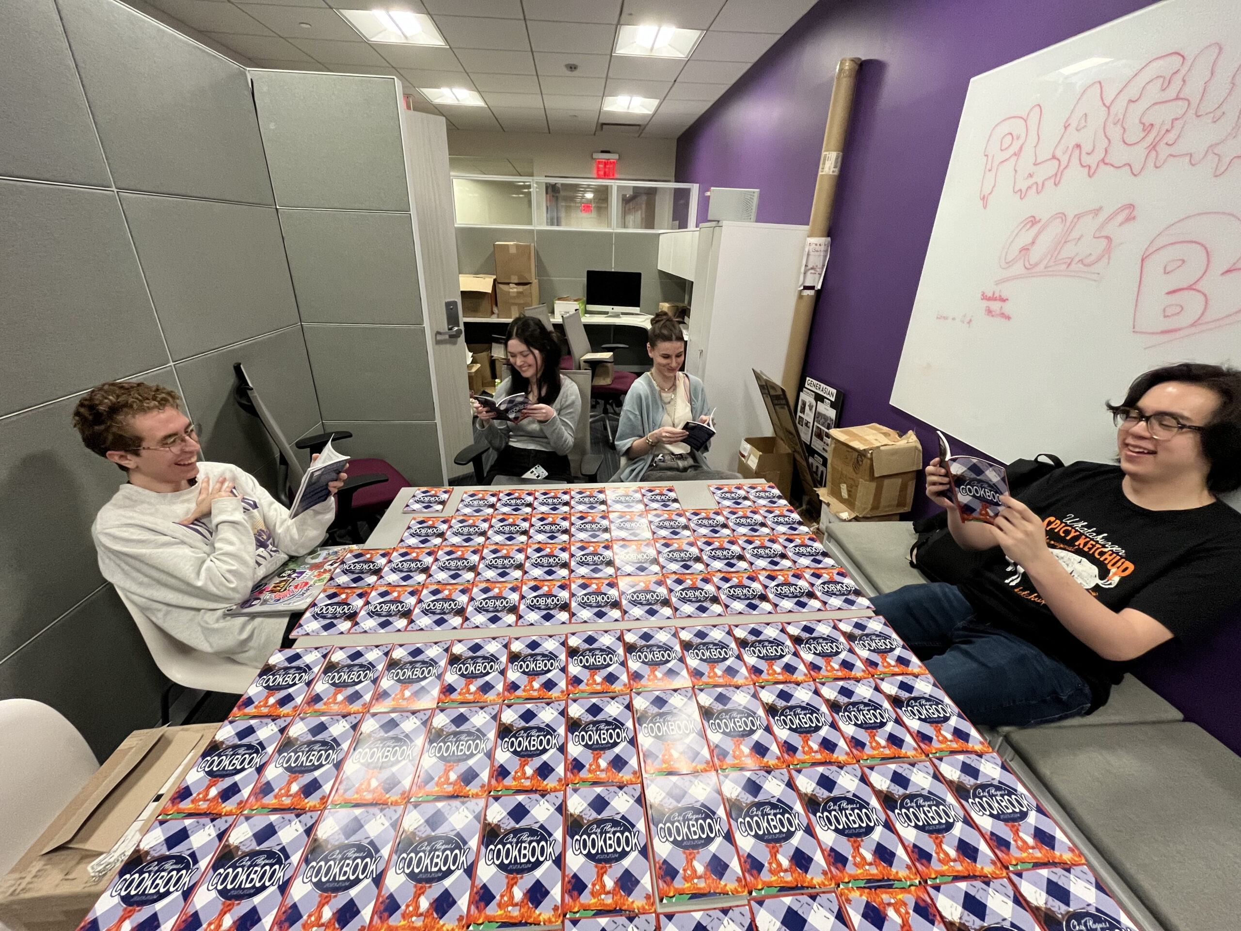 Four college students sit around a table full of copies of the latest “The Plague” magazine.