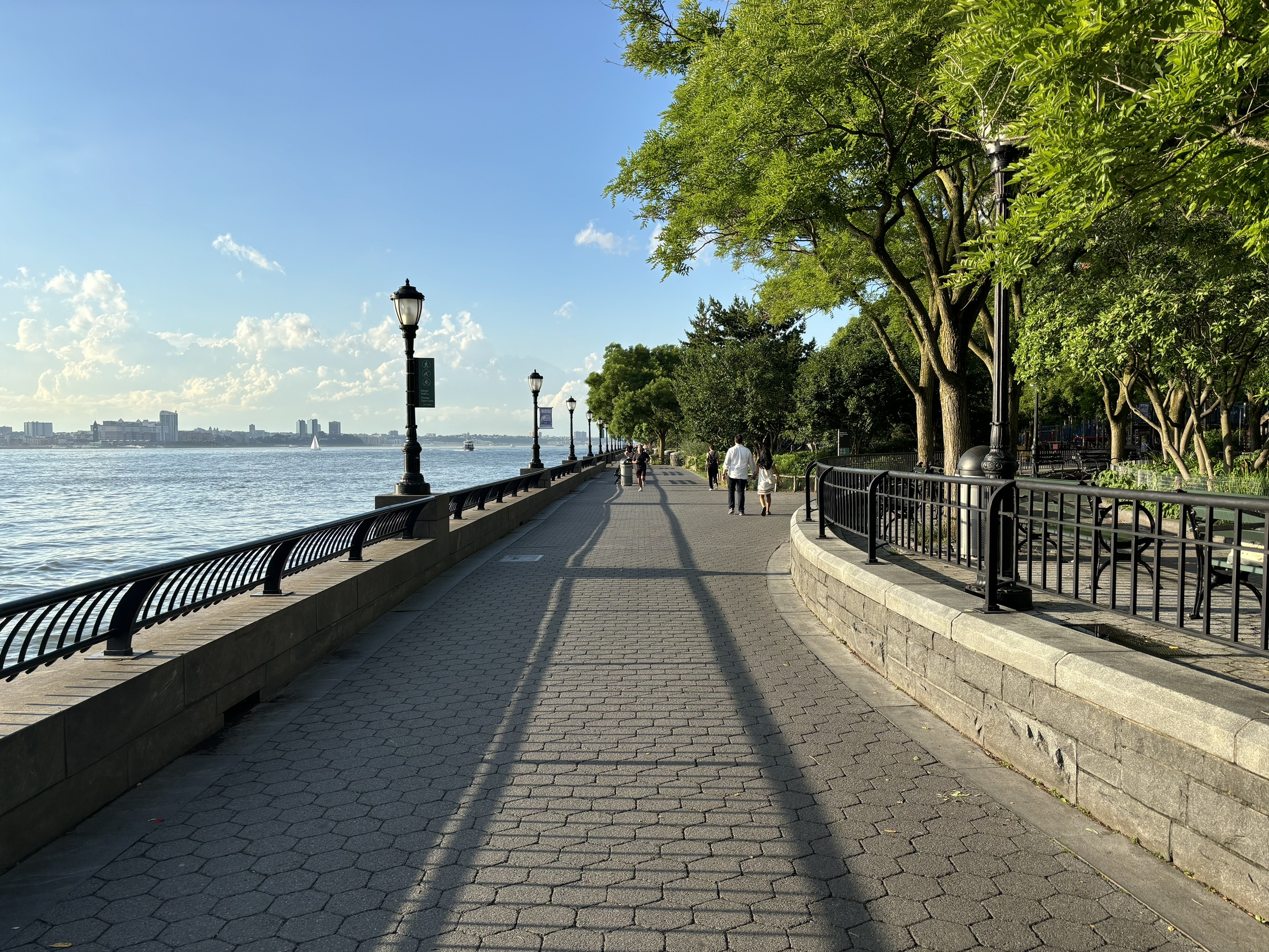 The Hudson River Park path on a sunny afternoon with Rockefeller Park to the right, and the Hudson River to the left