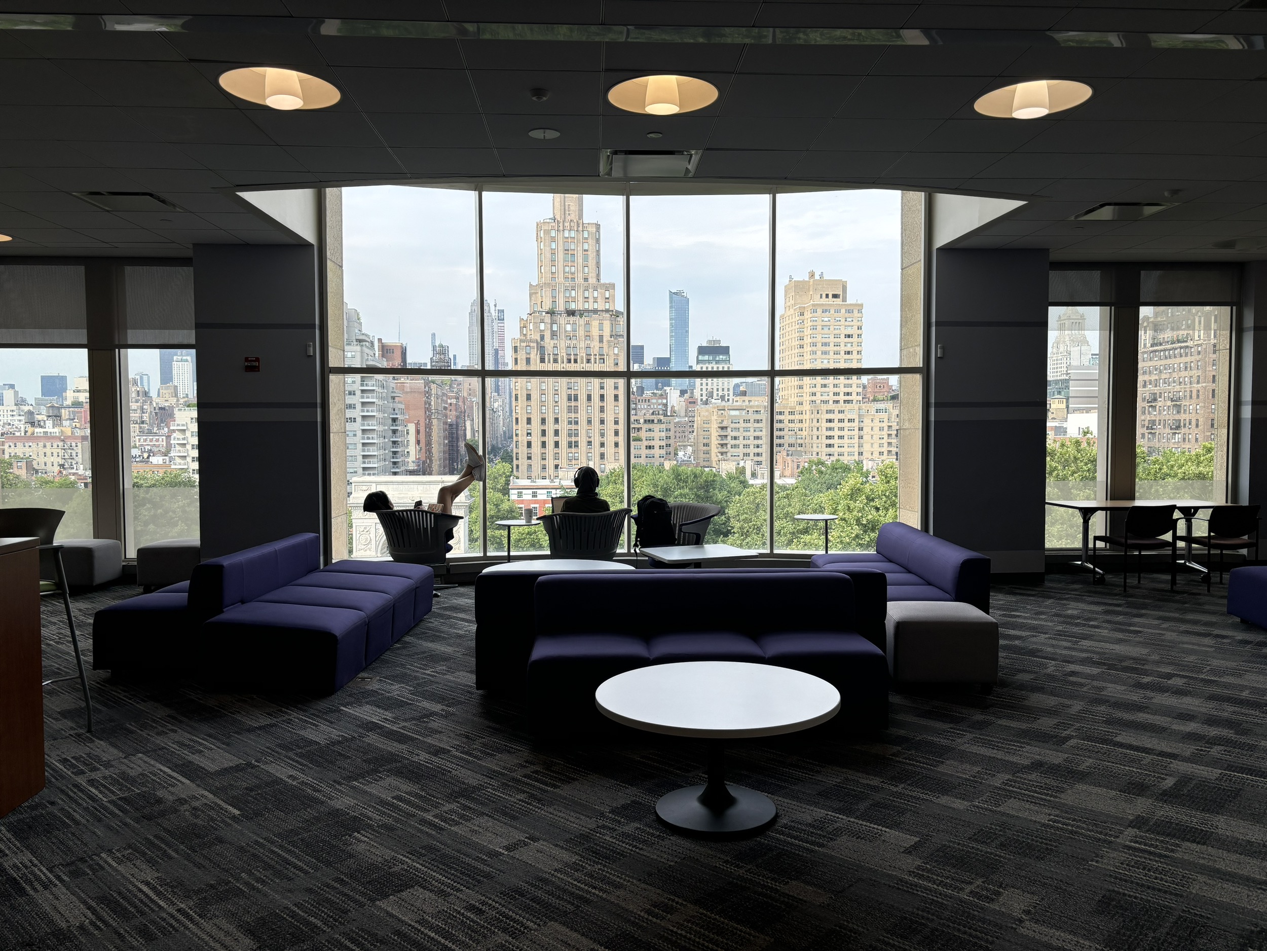 A wide view of the Katzell Lounge with a few students enjoying a chill study session