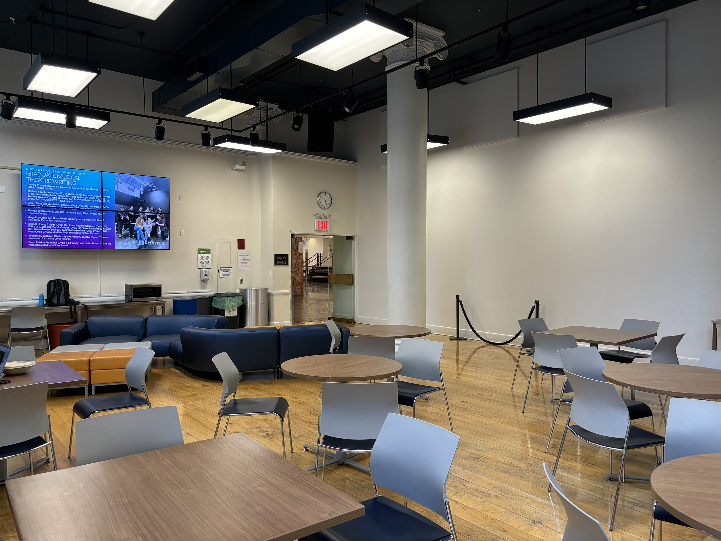 The Riese Lounge on the ground floor of Tisch with couches, tables and a wall monitor.