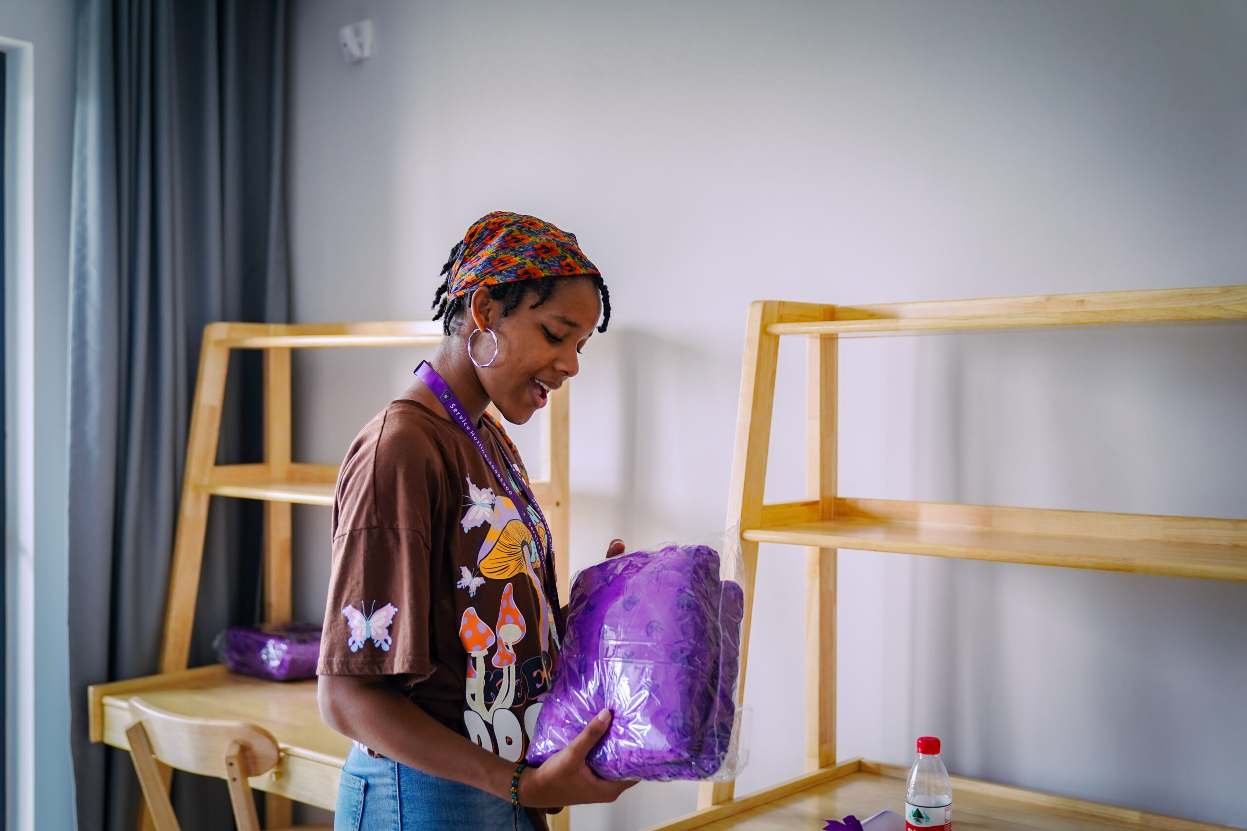 A NYUSH student unwraps a violet blanket