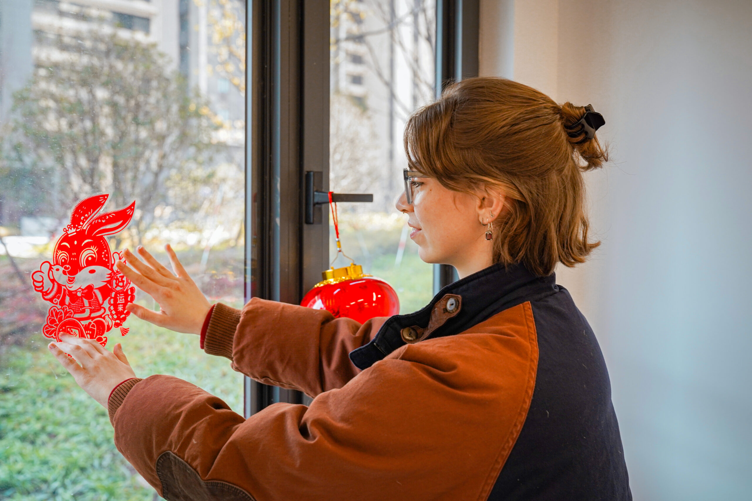 A student decorates their window with a Lunar New Year Rabbit decoration