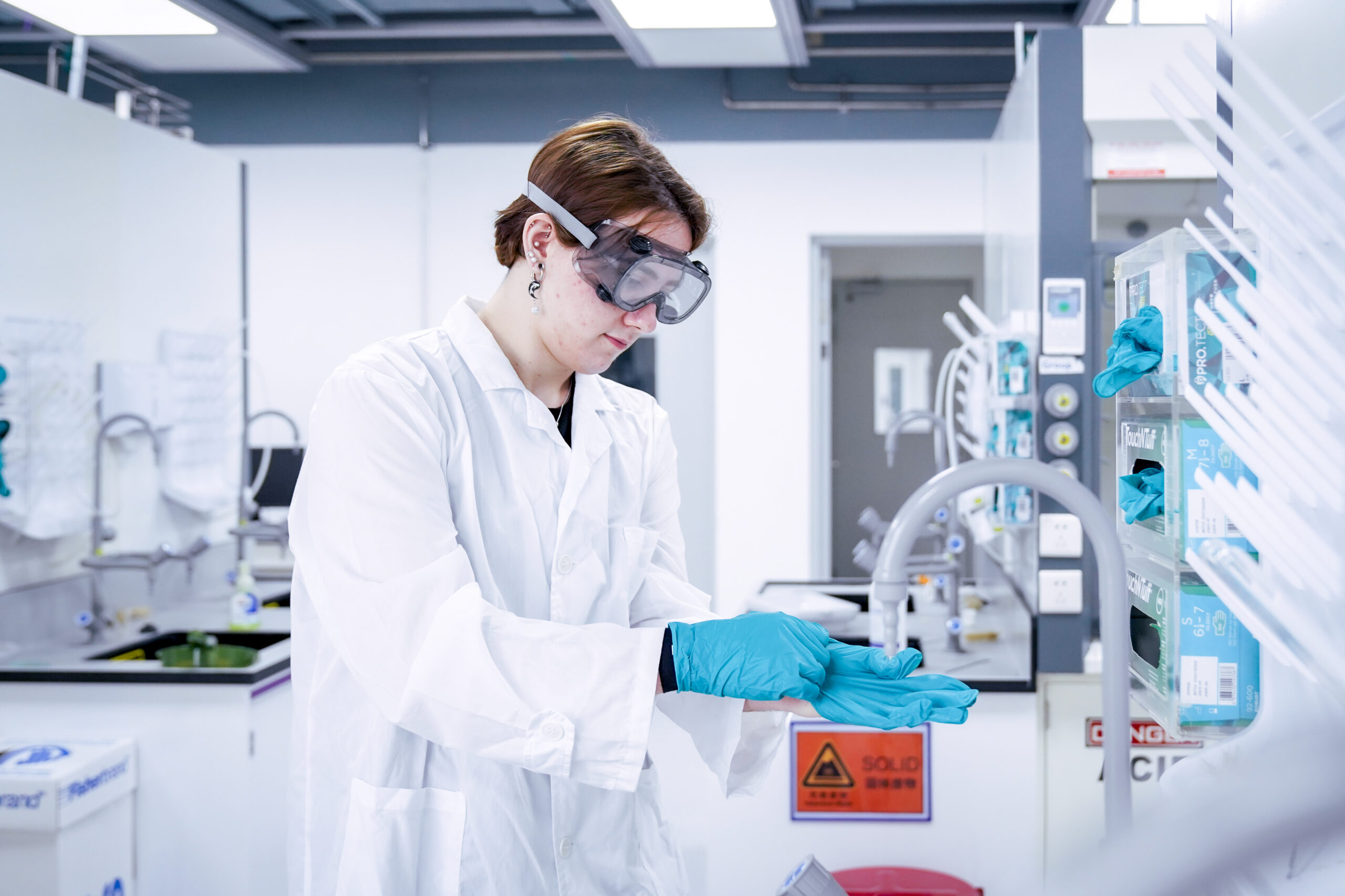 A student examines a lab faucet