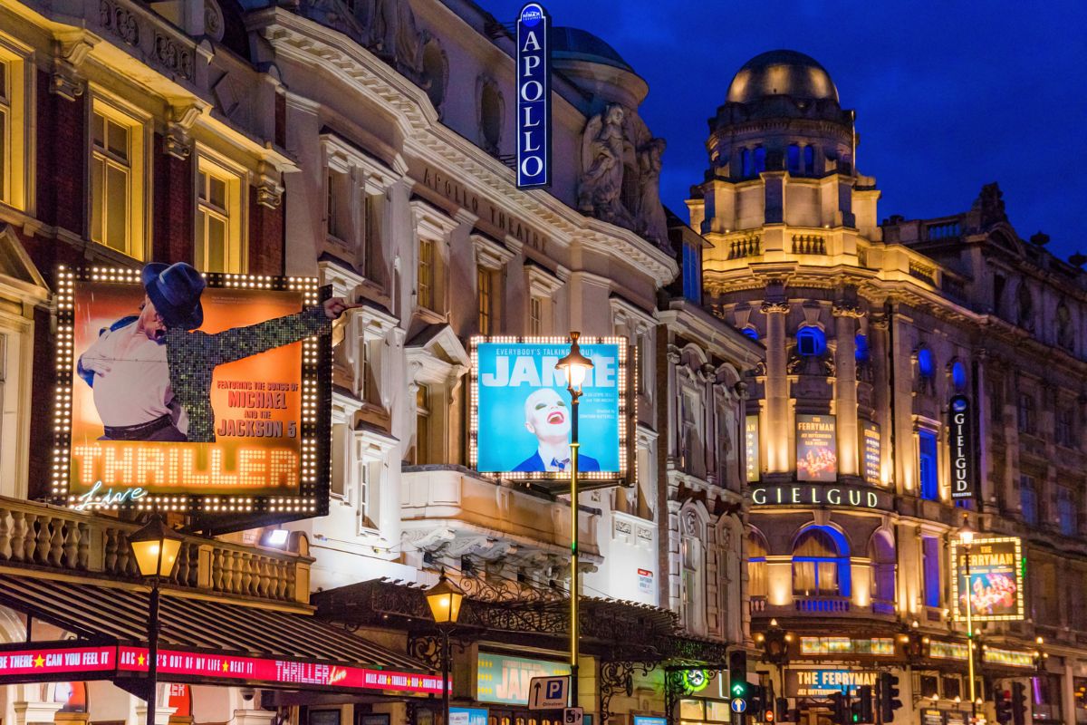 West End theatres in Leicester Square, London, lit up at night.
