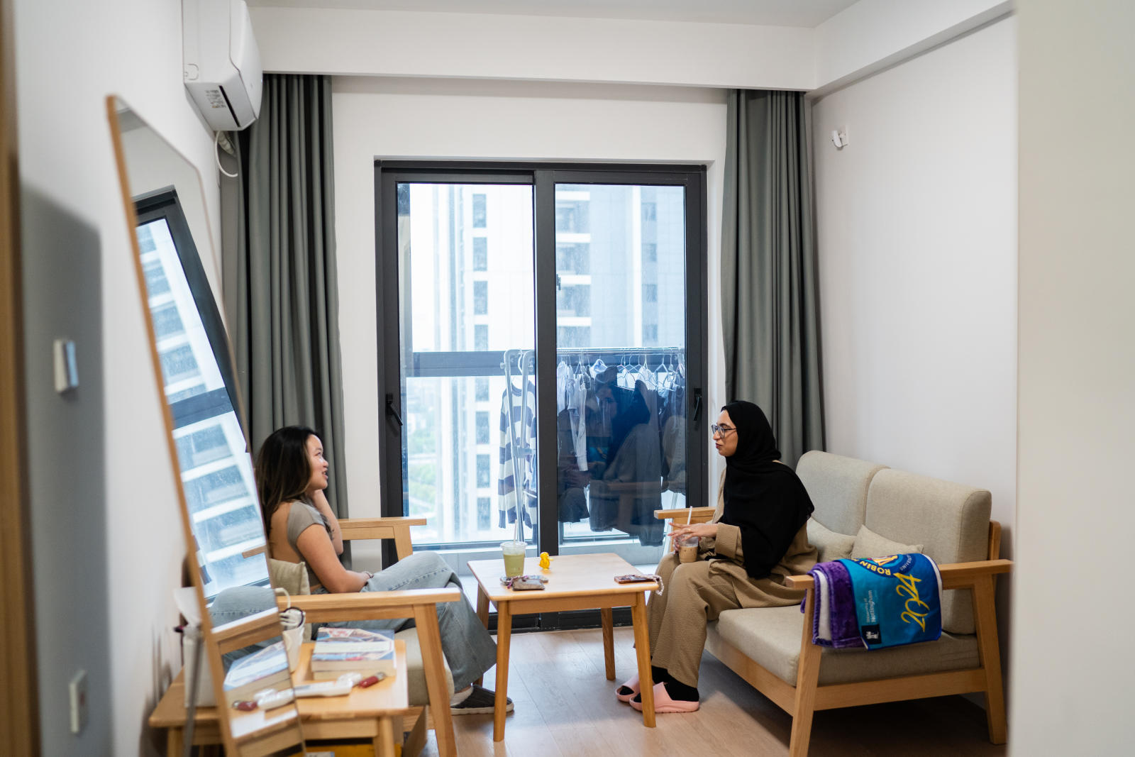 Two students sit facing each other in the Common room