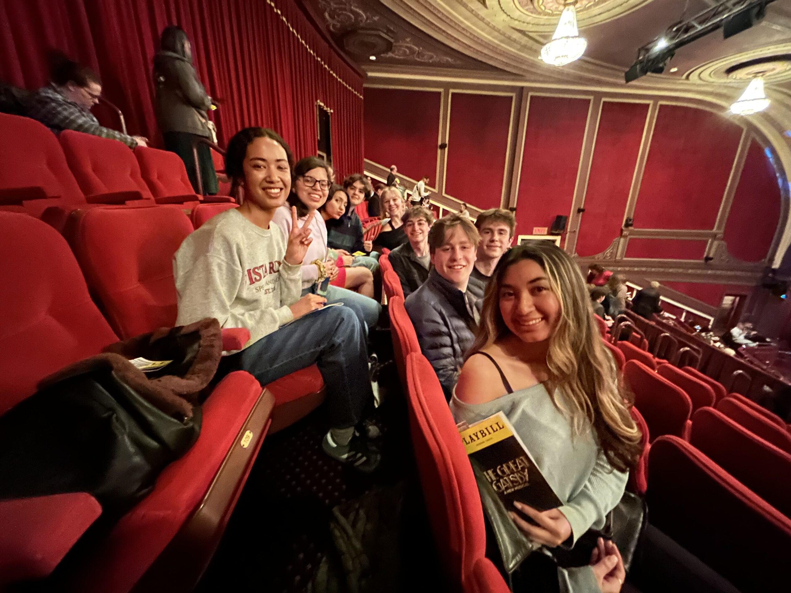 Students sitting in an audience row at a theatre.