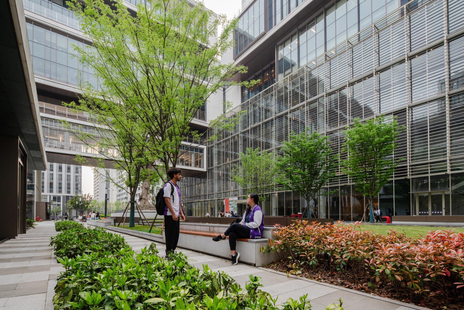 two students chat in the NYU Shanghai courtyard