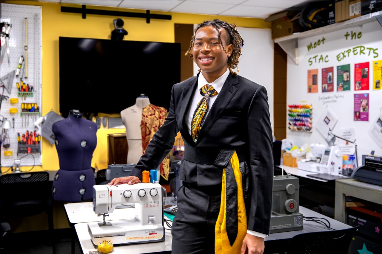 NYU Gallatin student Anthony Offiah standing in front of a sewing machine in his studio.