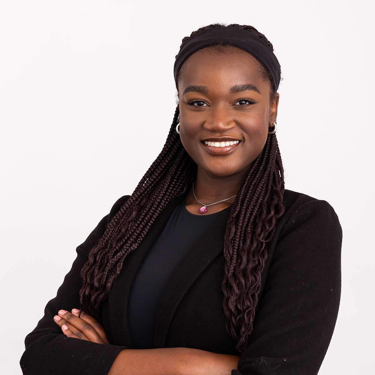 Angela Daudu smiles with her arms crossed in front of her.