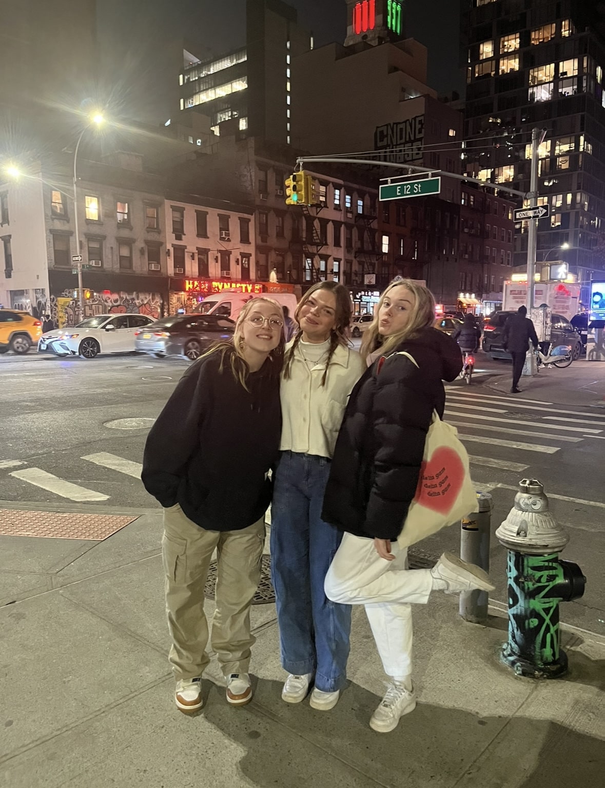 Three friends pose on a street in NYC.