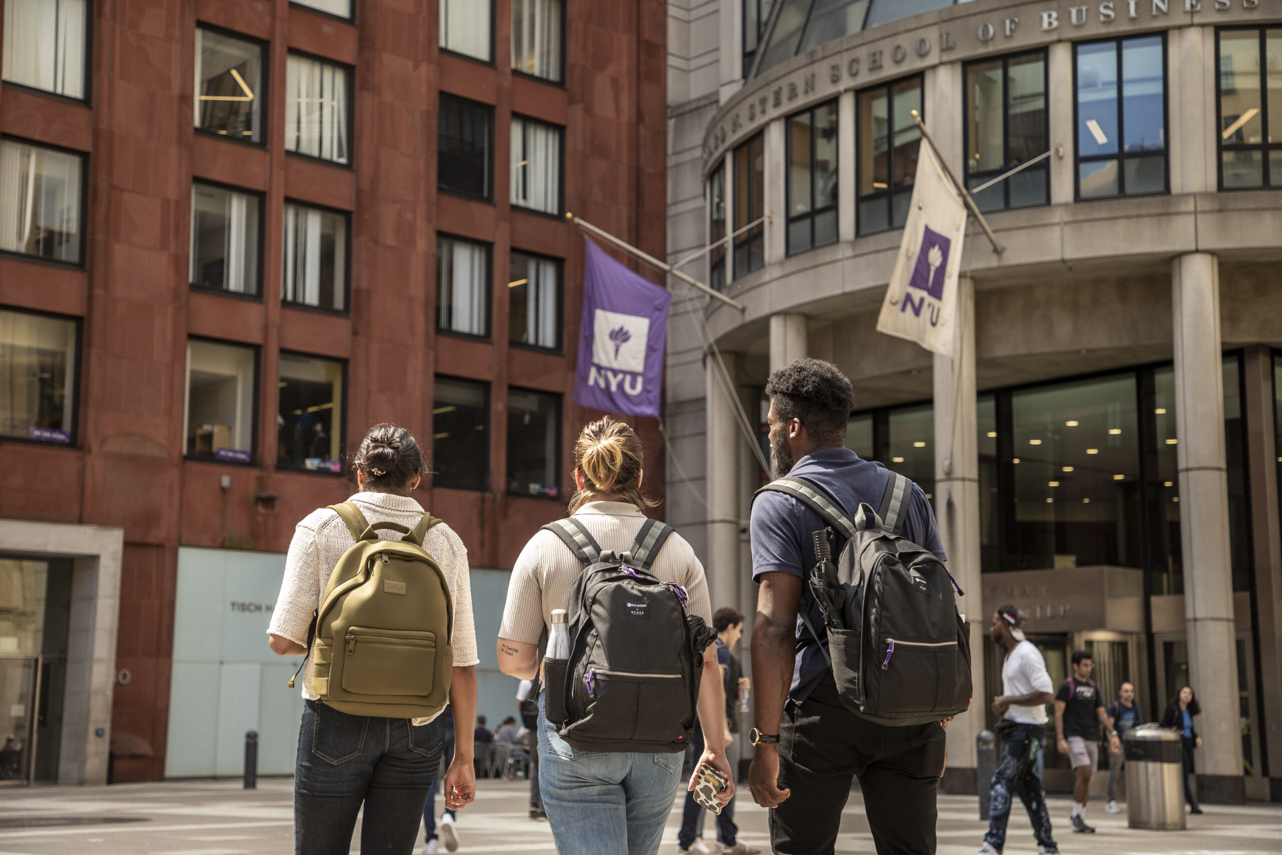 Three students walking on the NYU campus.