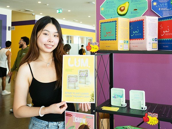 Student holding up a poster of their work.