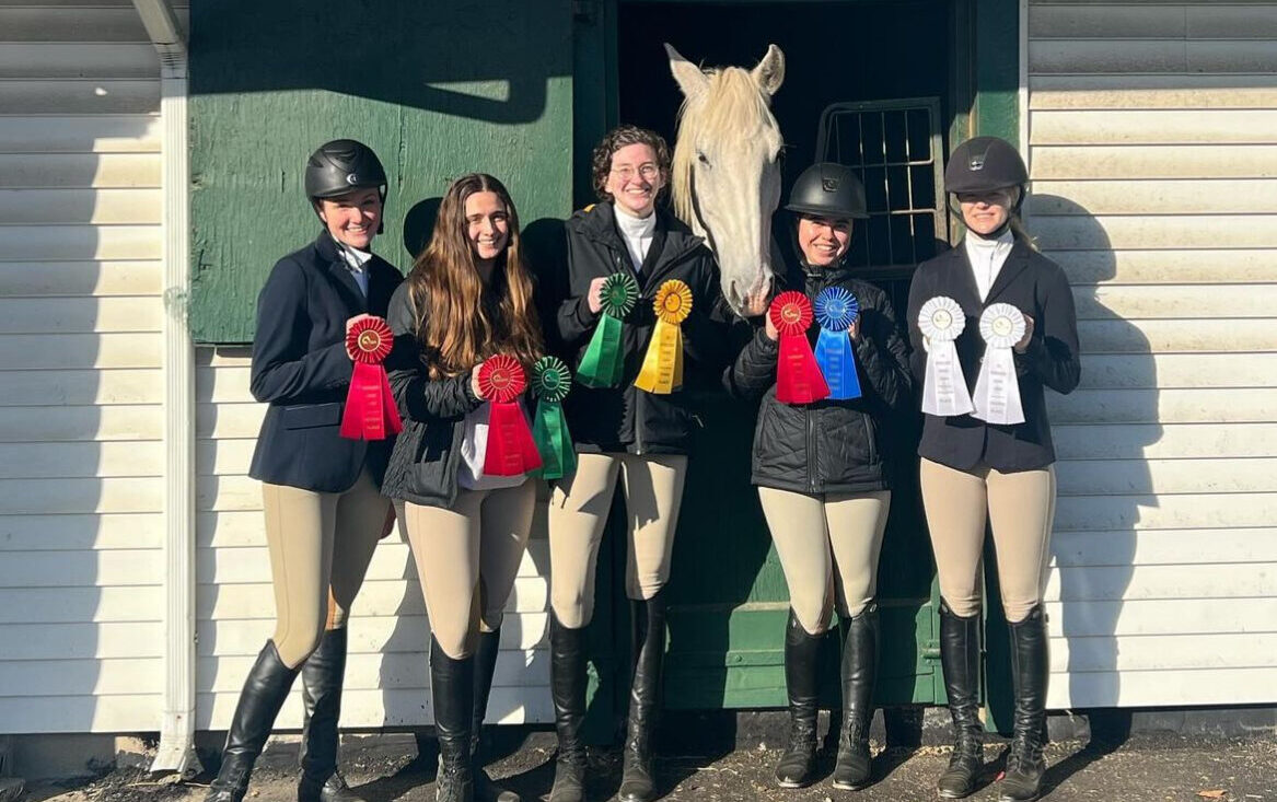 NYU Equestrian riders pose with their ribbons after a competition