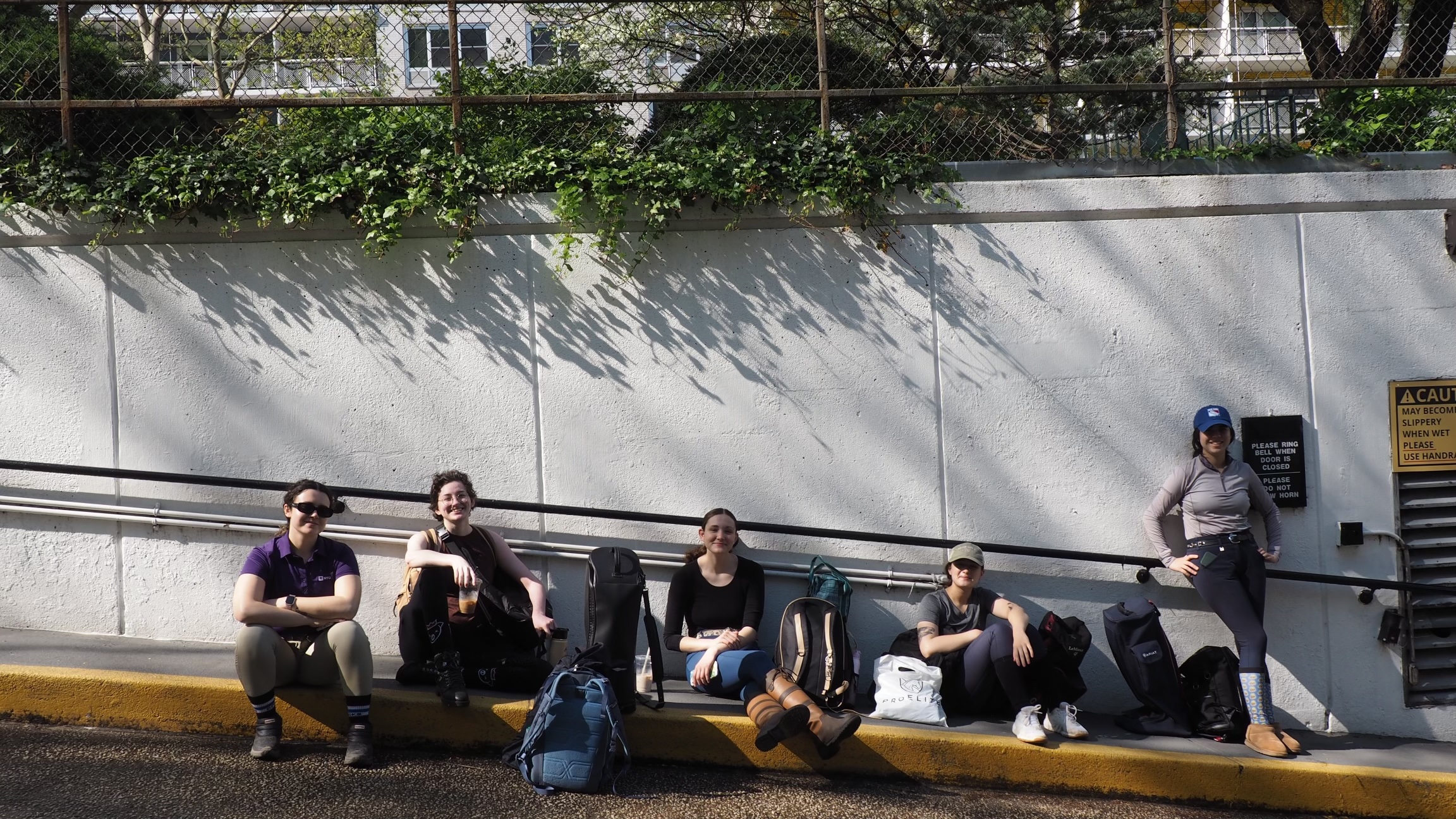 Riders leaning against wall with their riding gear