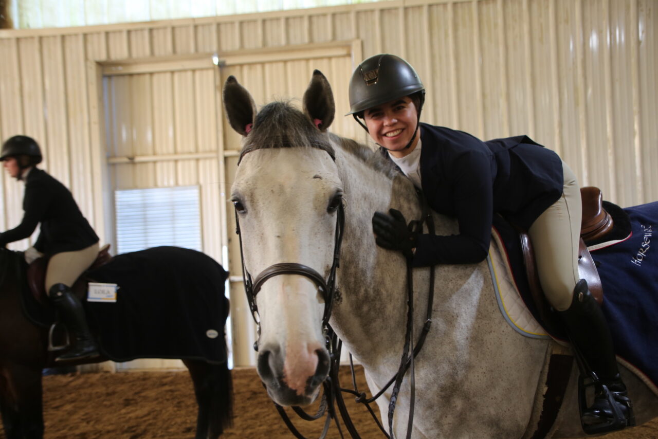 A rider hugs her horse