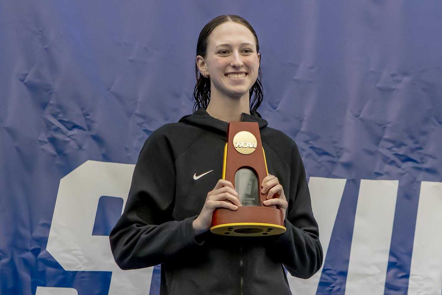 Kaley McIntyre holding up her award from a swim competition.