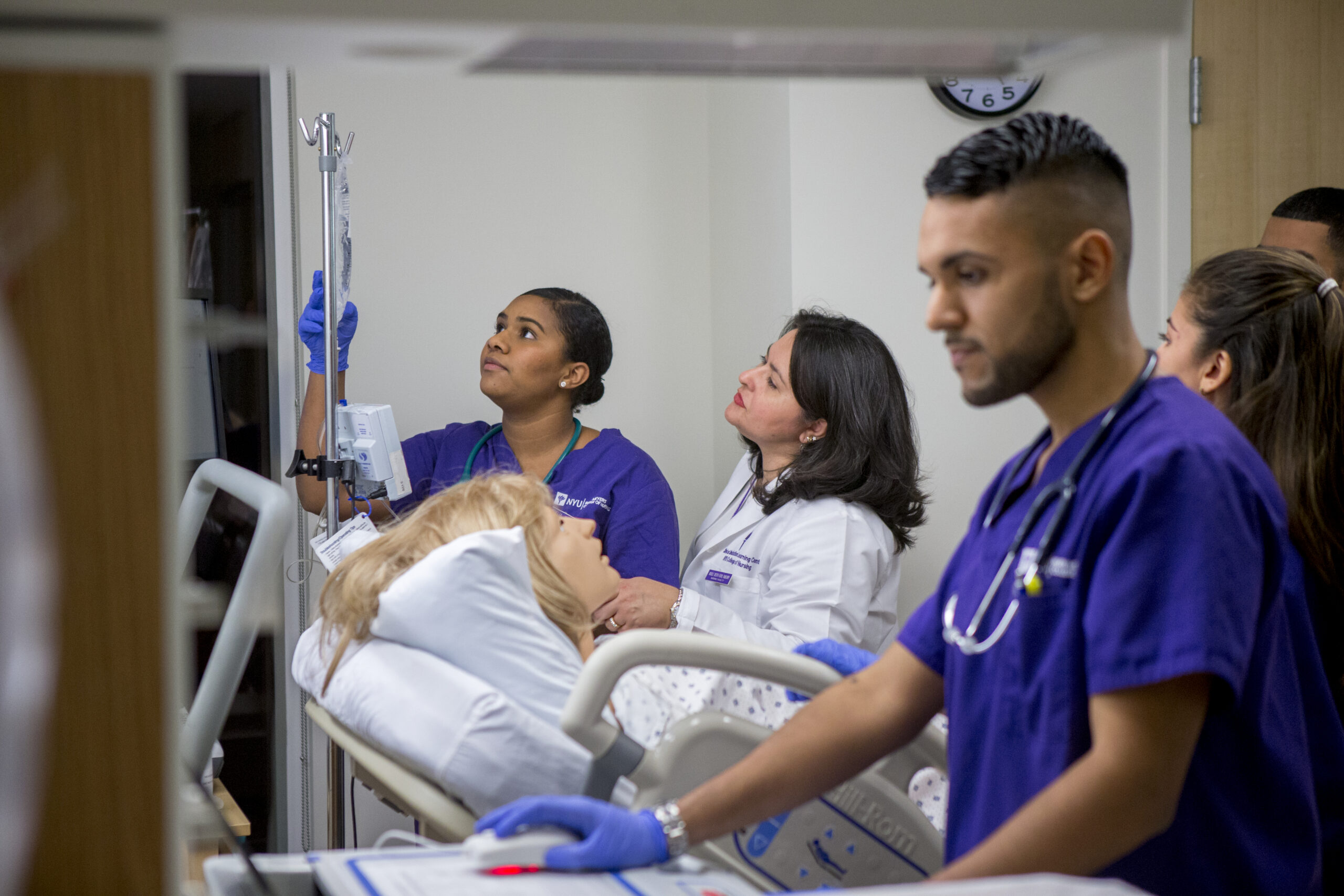 Students and professor working together in a nursing simulation lab