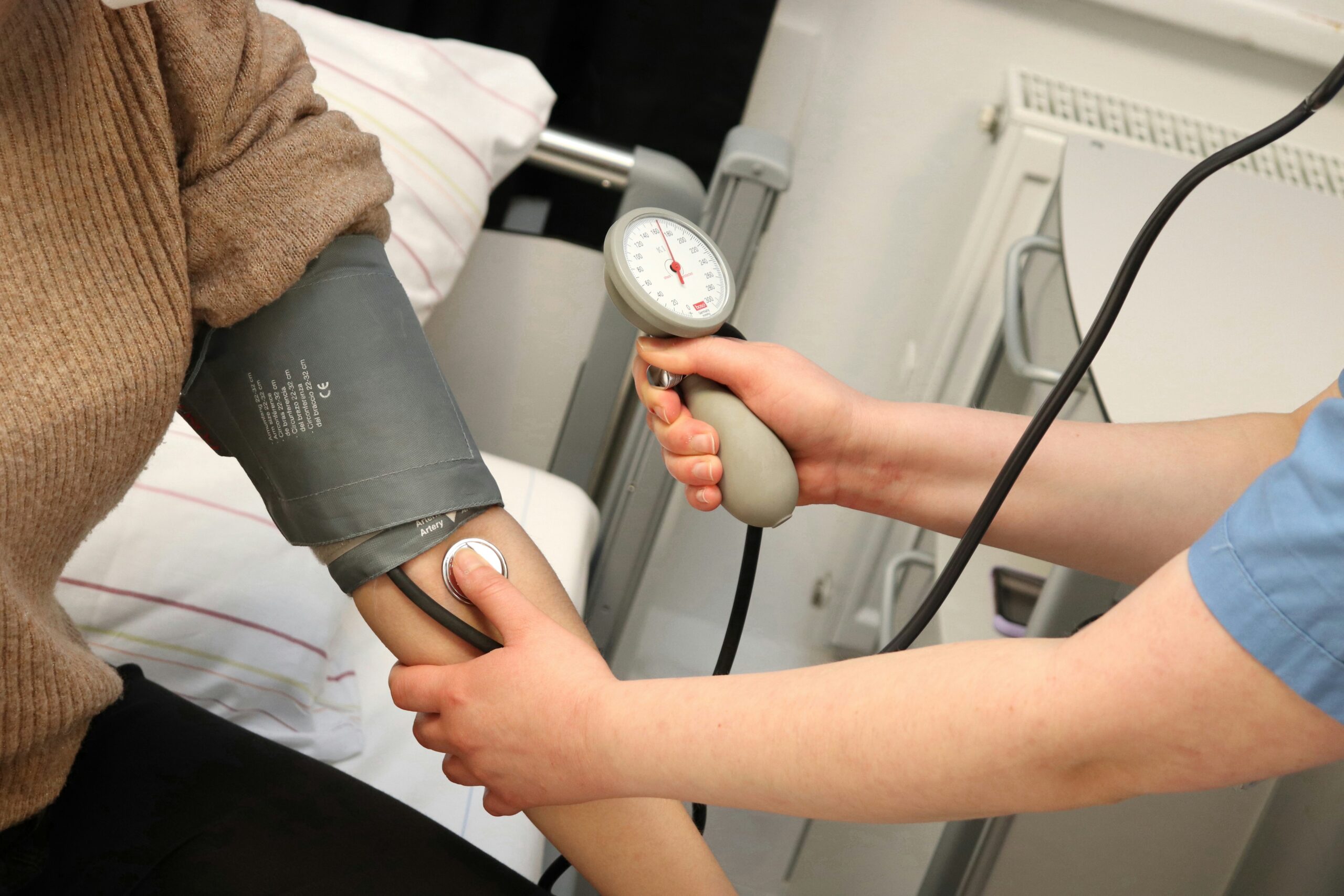 A healthcare professional taking someone’s blood pressure.