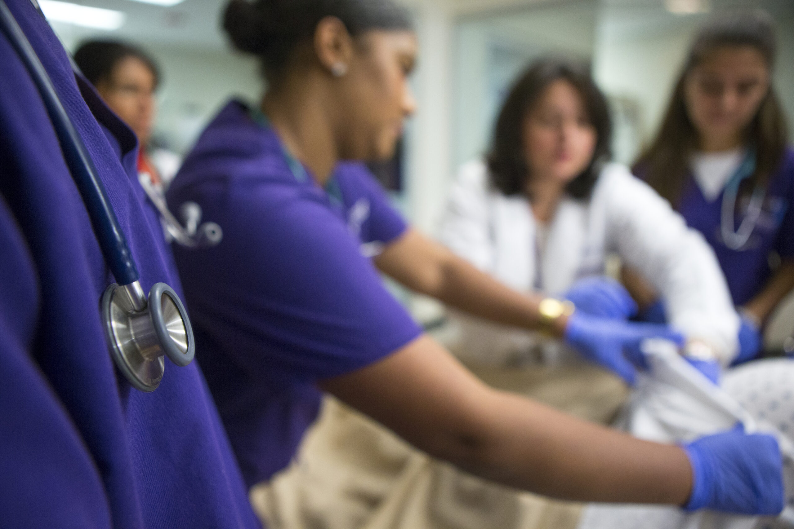 Students and professor working together in a nursing simulation lab.