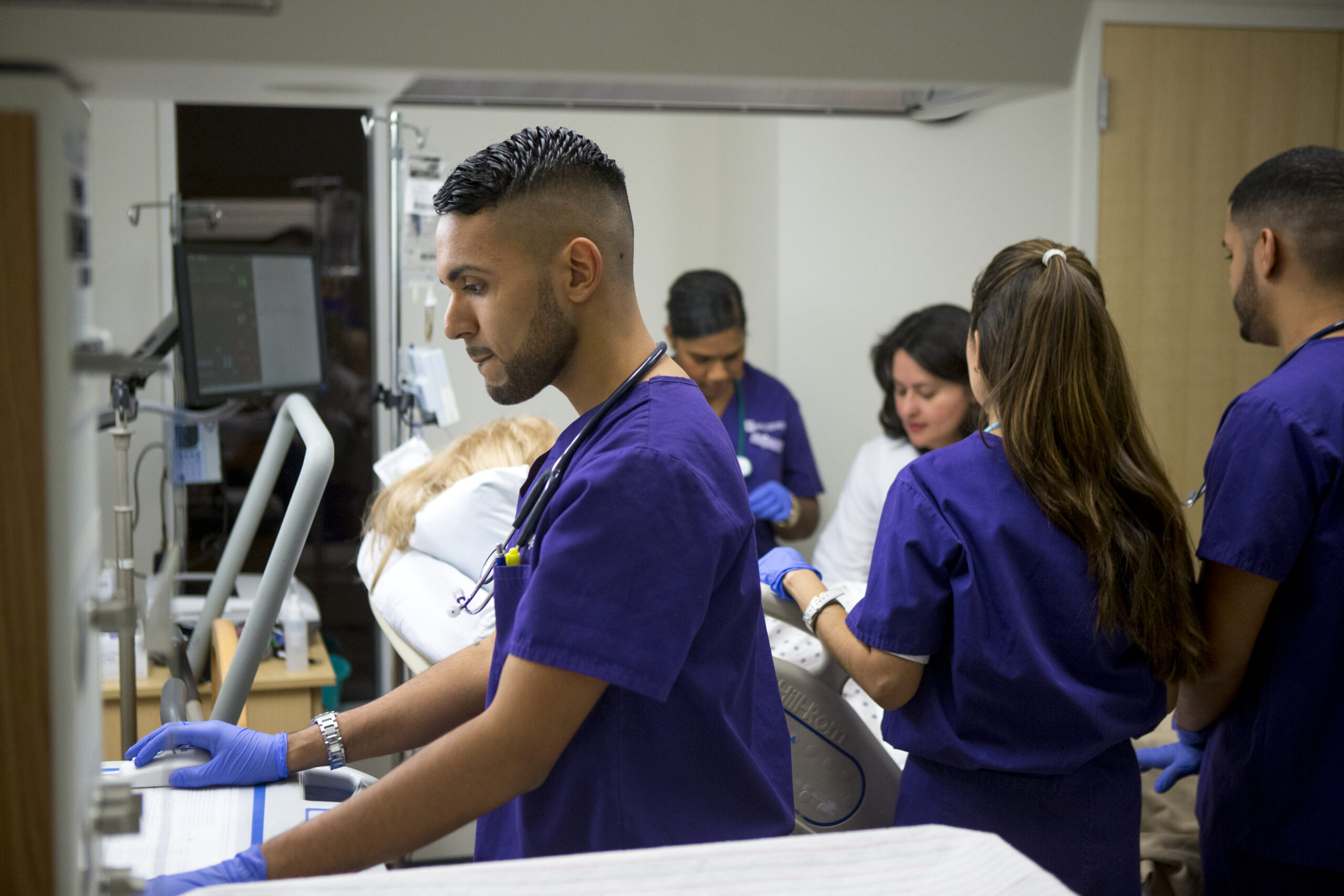 Students and professor working together in a Nursing simulation lab