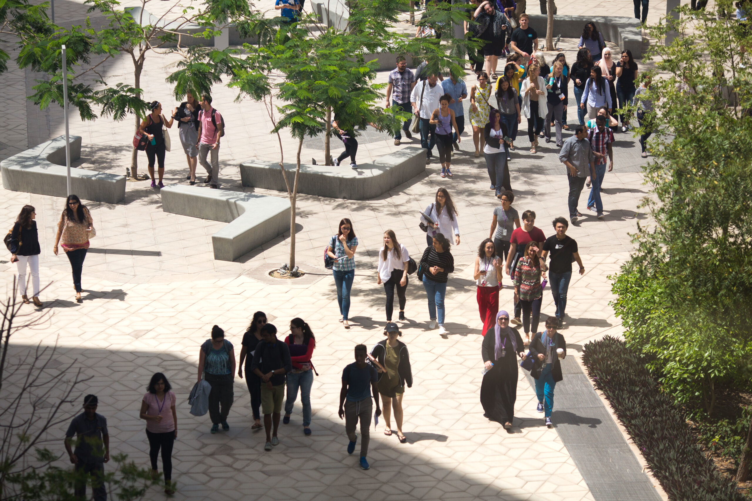 A large group of students walking on the NYU Abu Dhabi campus.