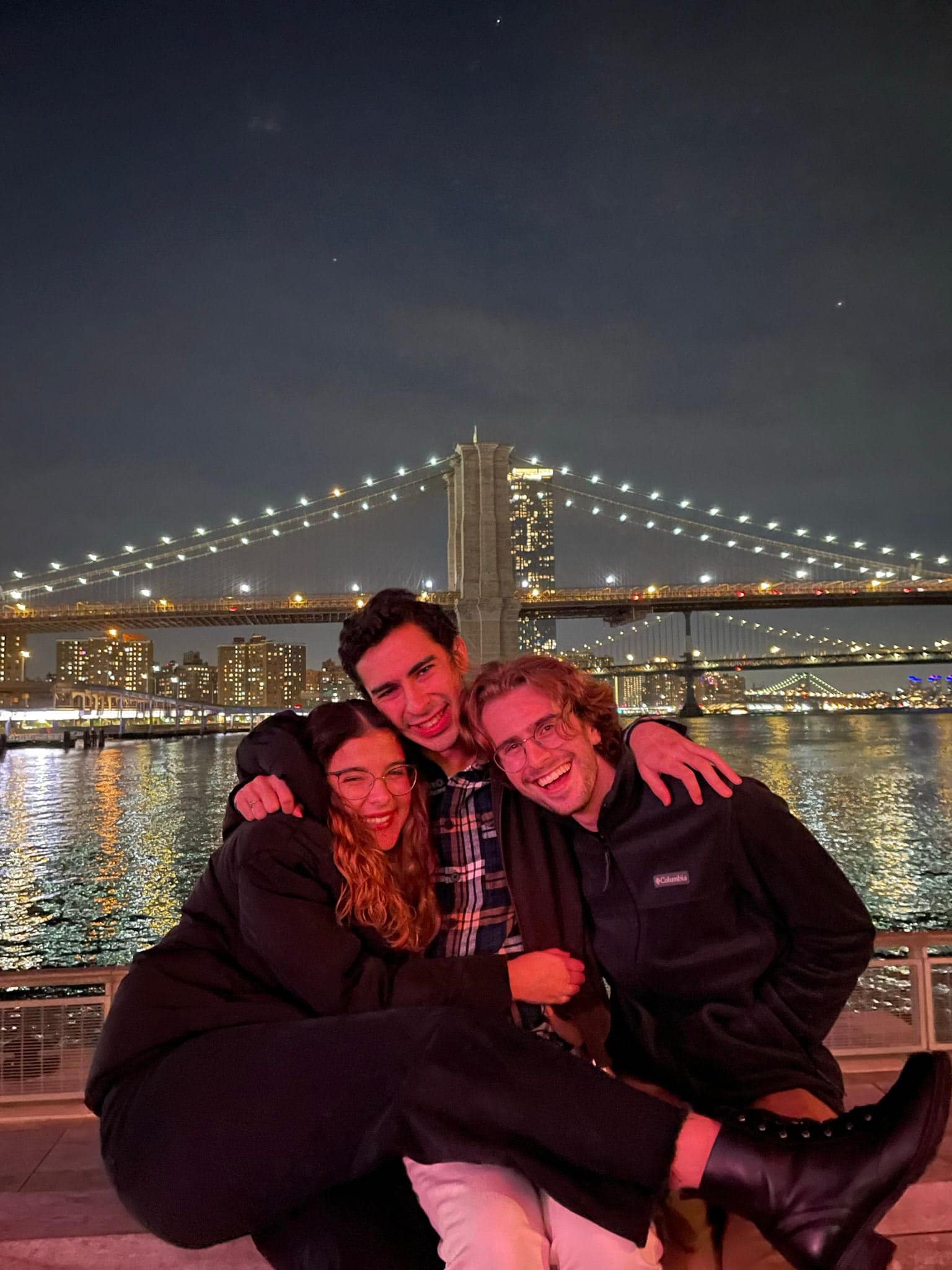 Three students enjoying the views of the Brooklyn Bridge