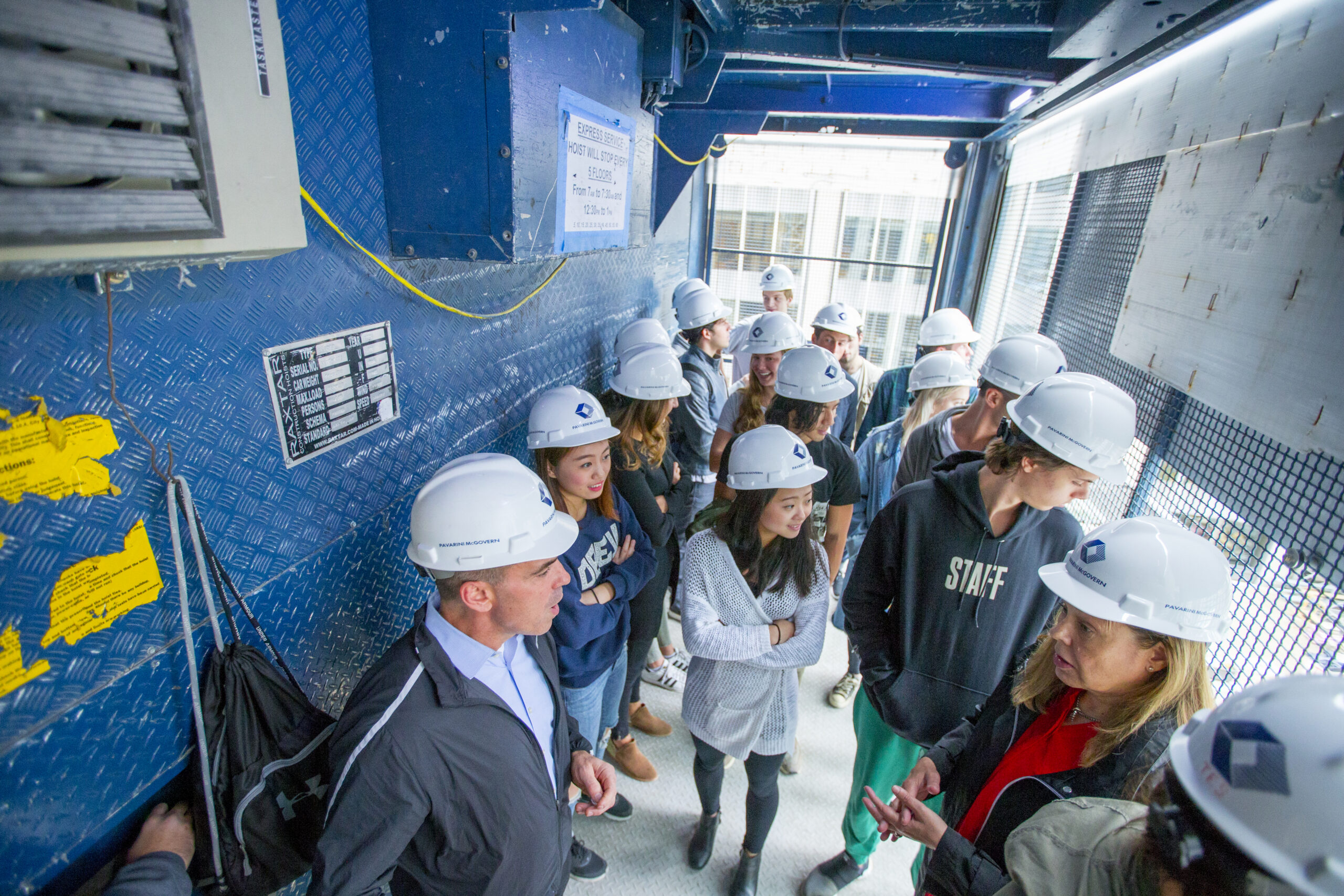 A large group of students in hard hats during a site tour.